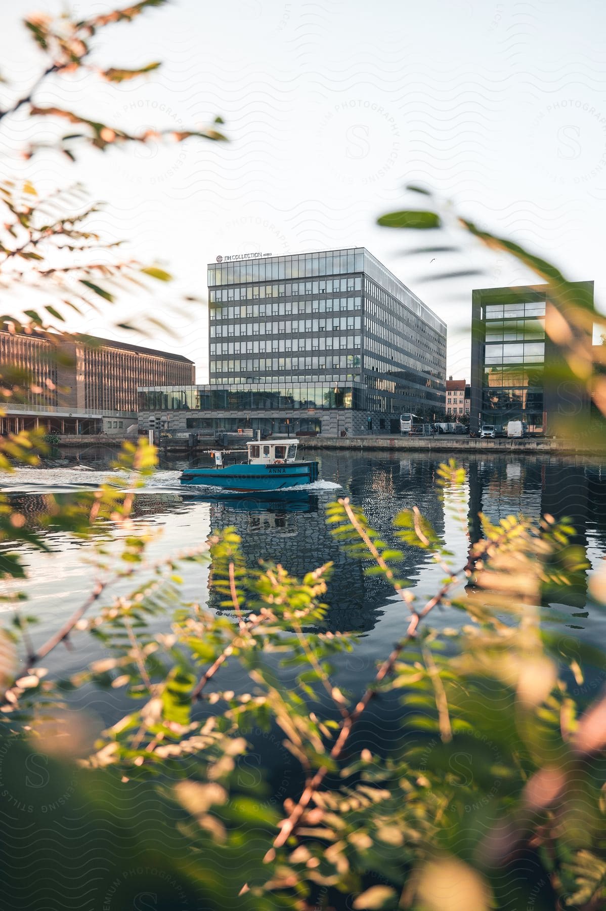 A serene urban waterfront with a boat and office building