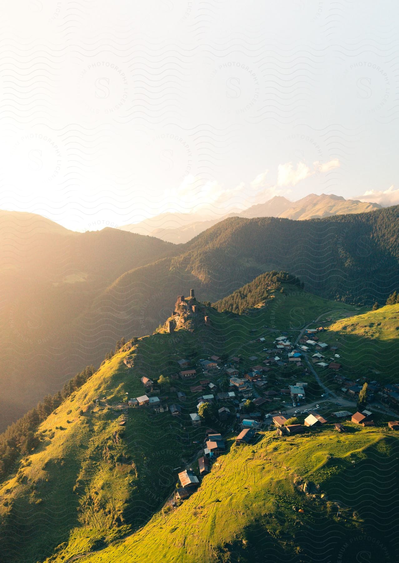 A Small Town Rests On A Flat Peak Of A Mountain Overlooking The Forest And Valley On A Cloudy Day In The Country Of Georgia