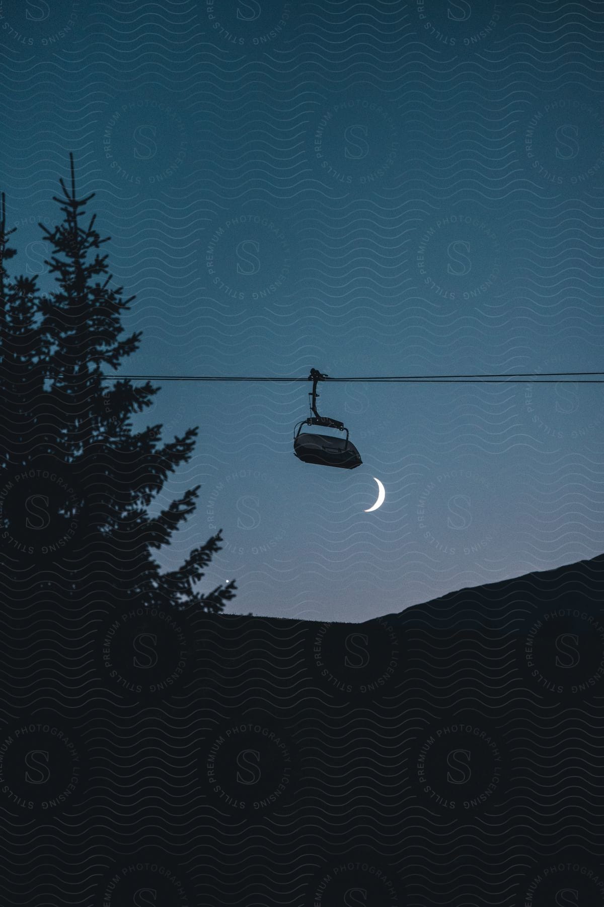 A ski lift is visible under a crescent moon in italy