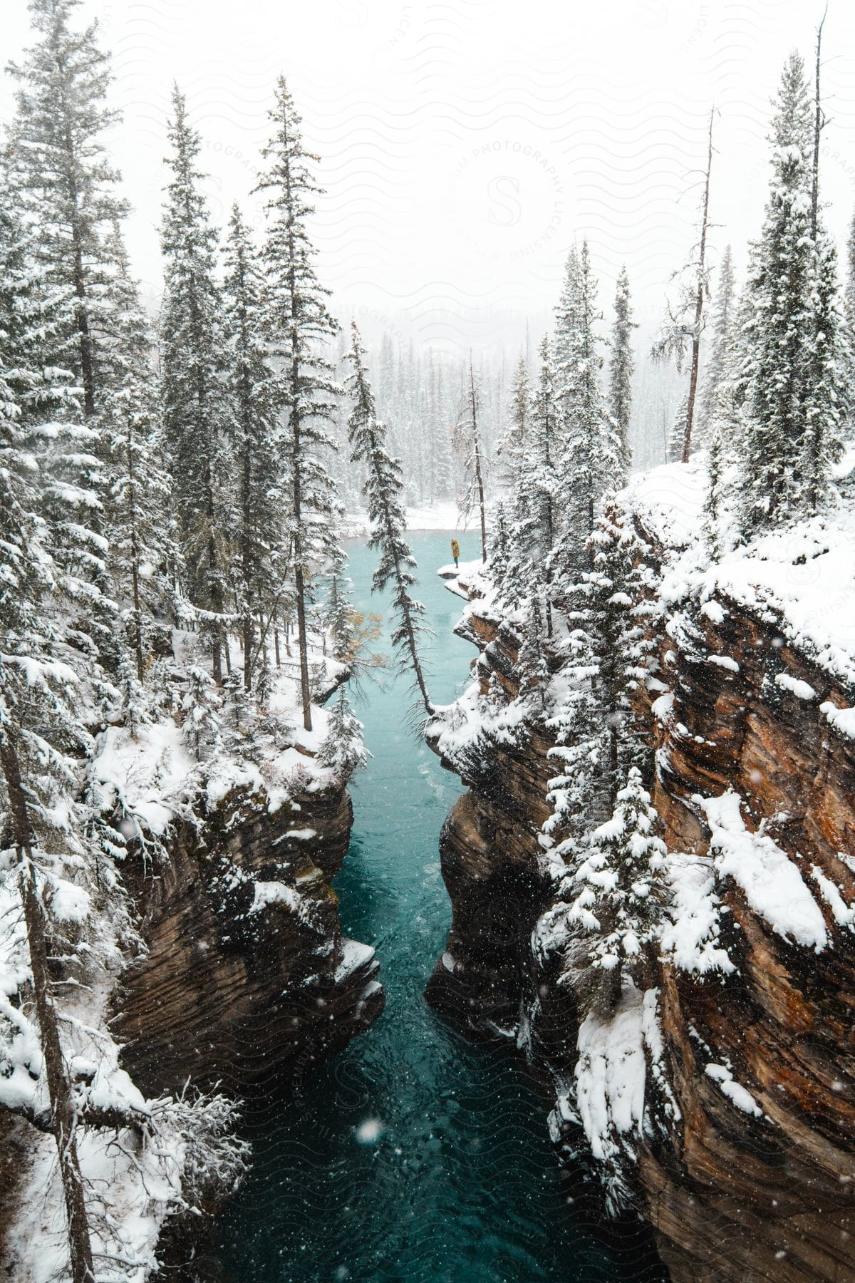 A snowcovered canyon surrounds a lake in canada