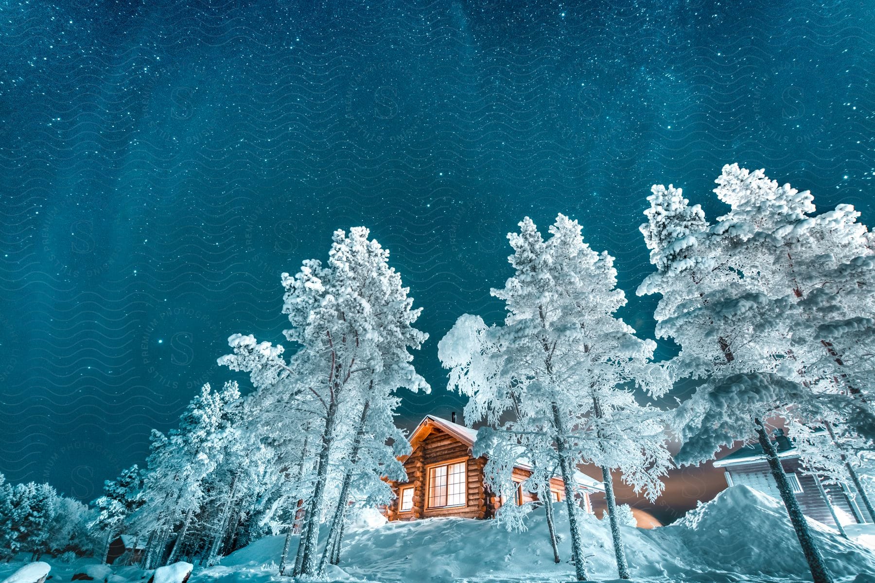 Wooden house surrounded by snow and frozen trees in finland