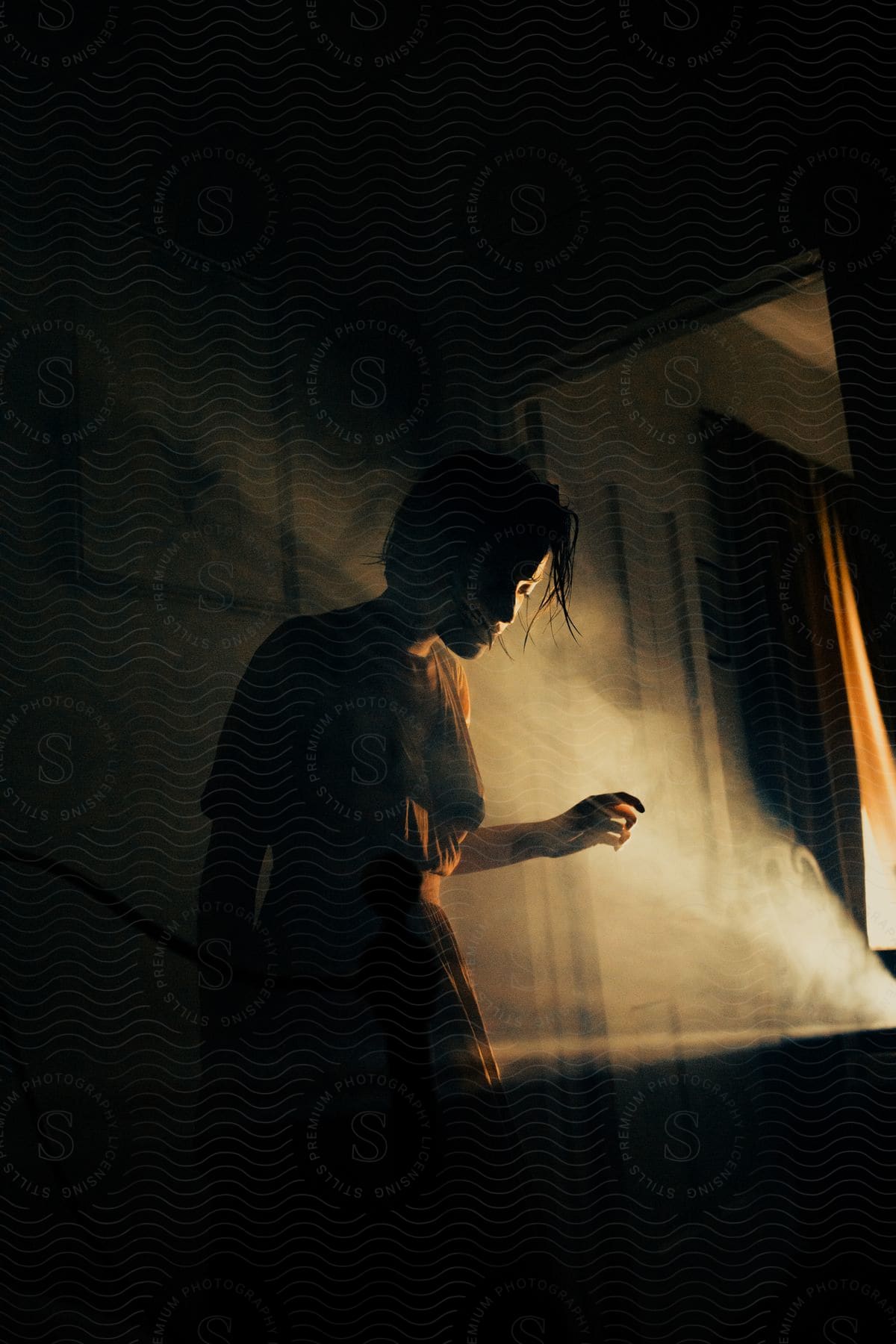 Woman standing in shadows next to a source of light half of her face illuminated