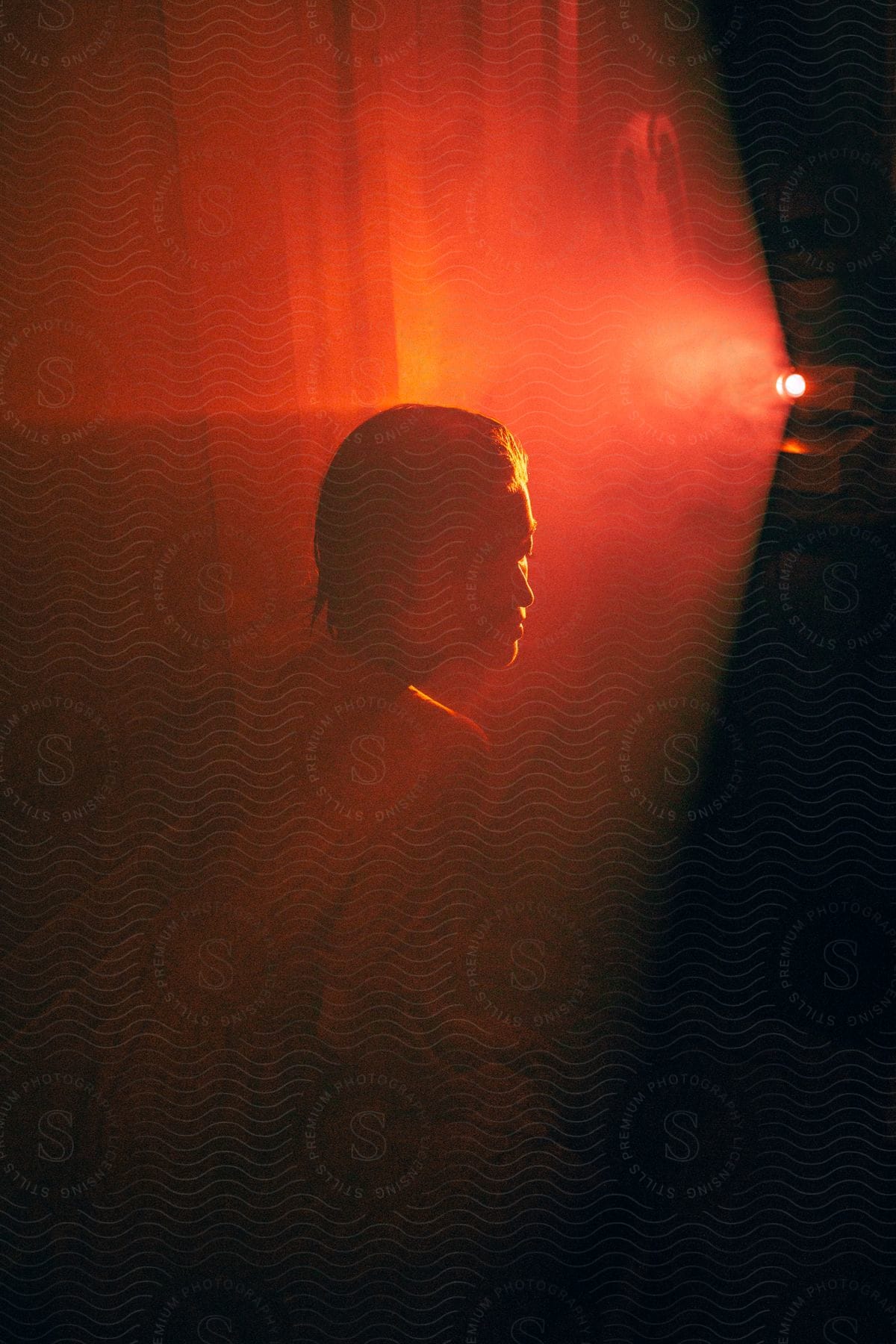 A young woman sits on the floor of a room in front of a projector