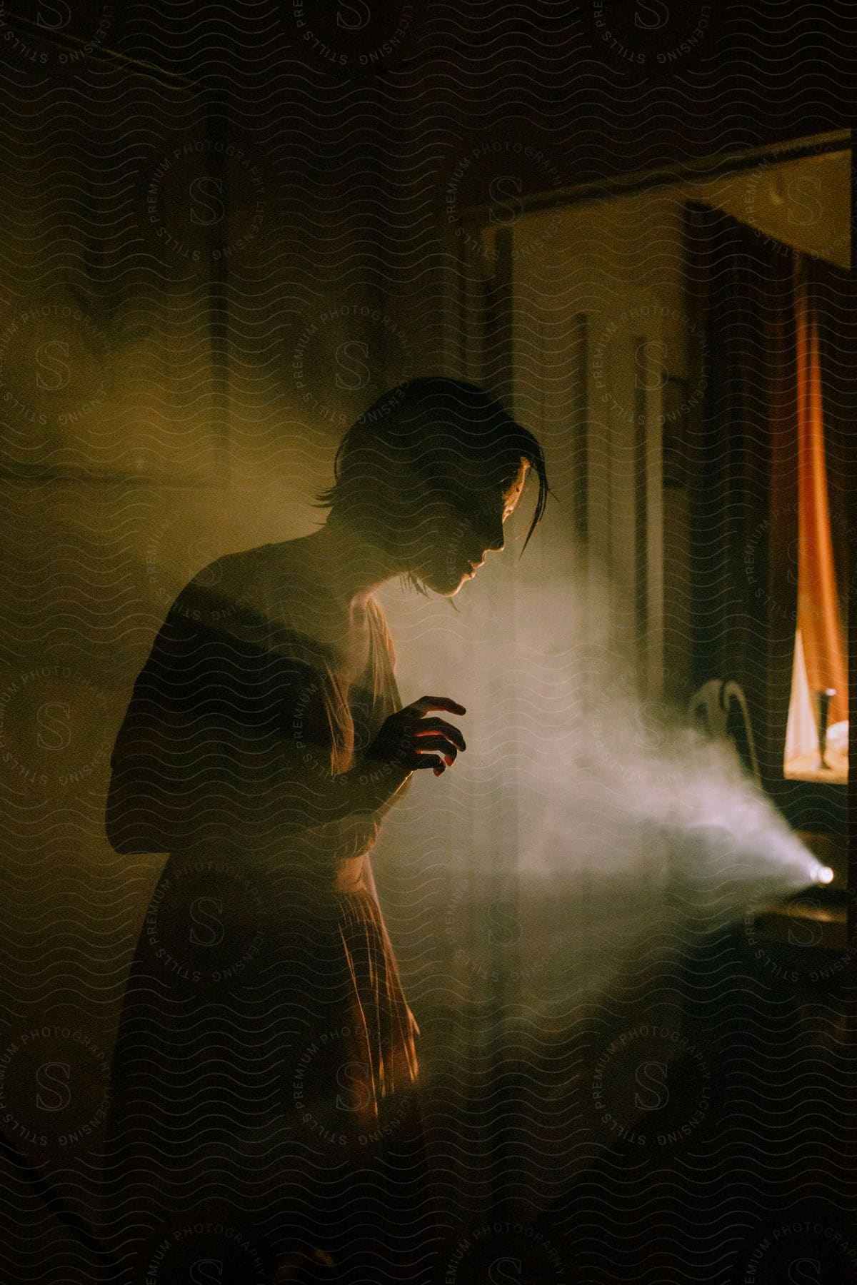 A woman standing indoors with steam rolling over her face