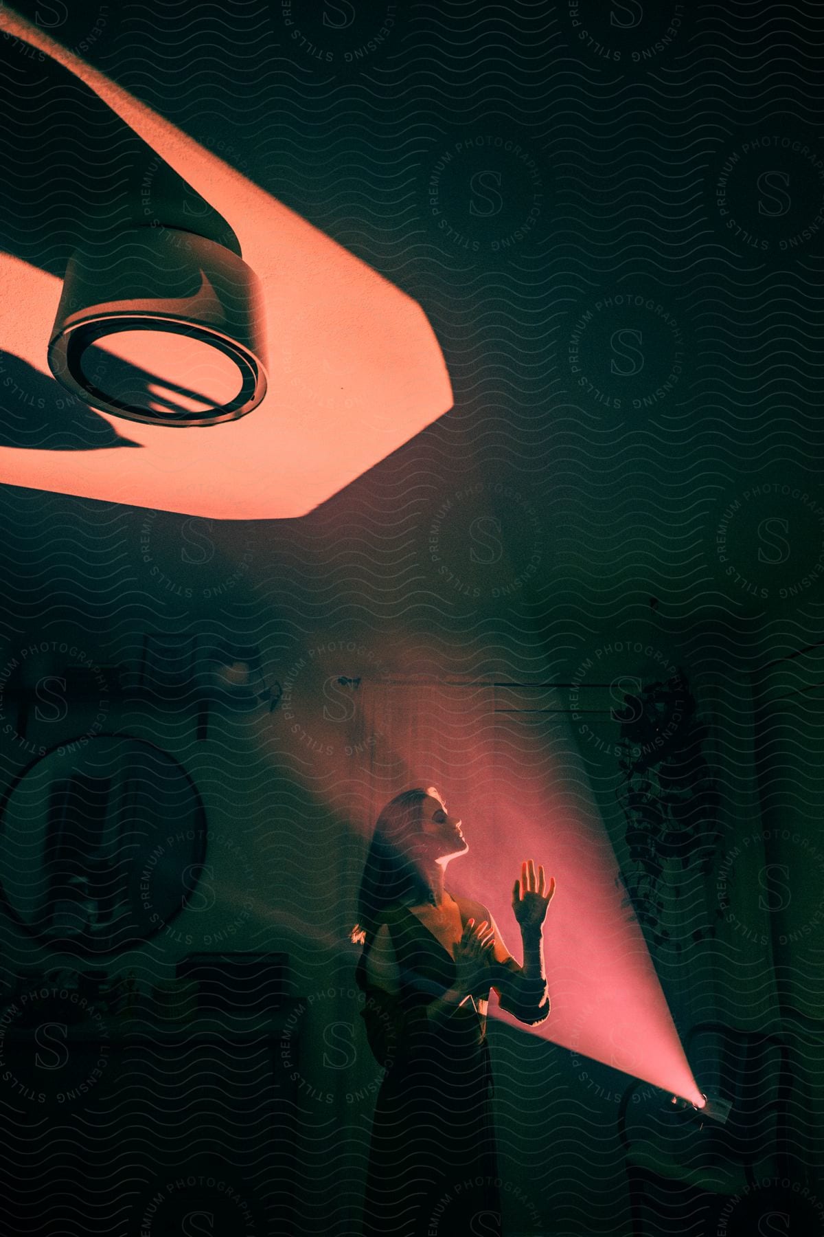 Woman wearing a dress standing in front of a projector light in a dark room