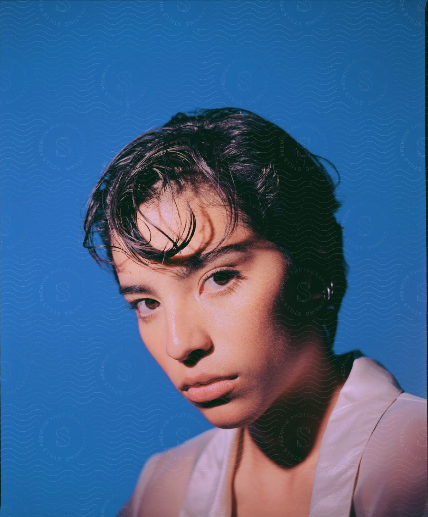 A lady with short hair looking intently exuding a strong and angry expression