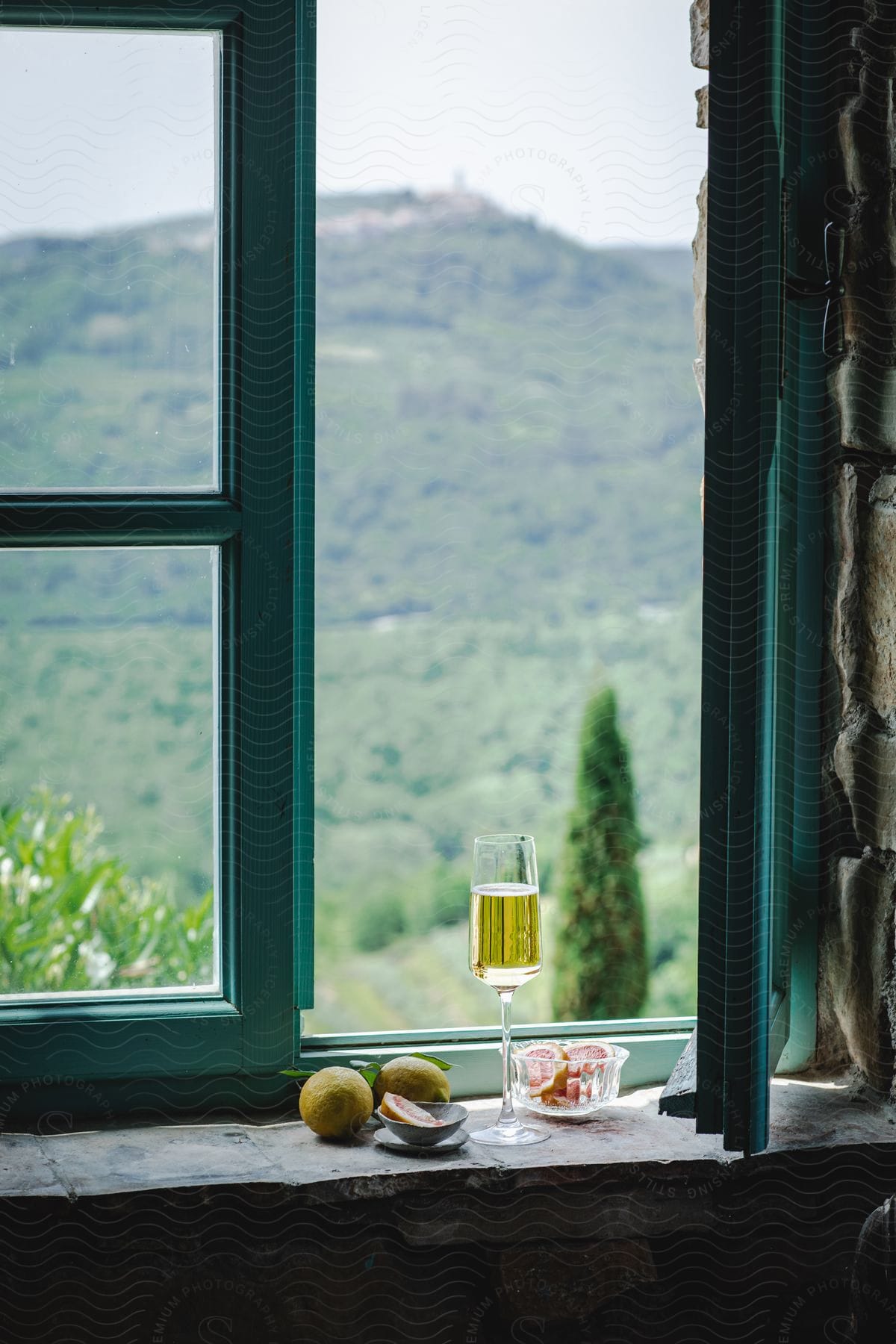 Stock photo of a glass of drink on a windowsill with a mountain on the horizon