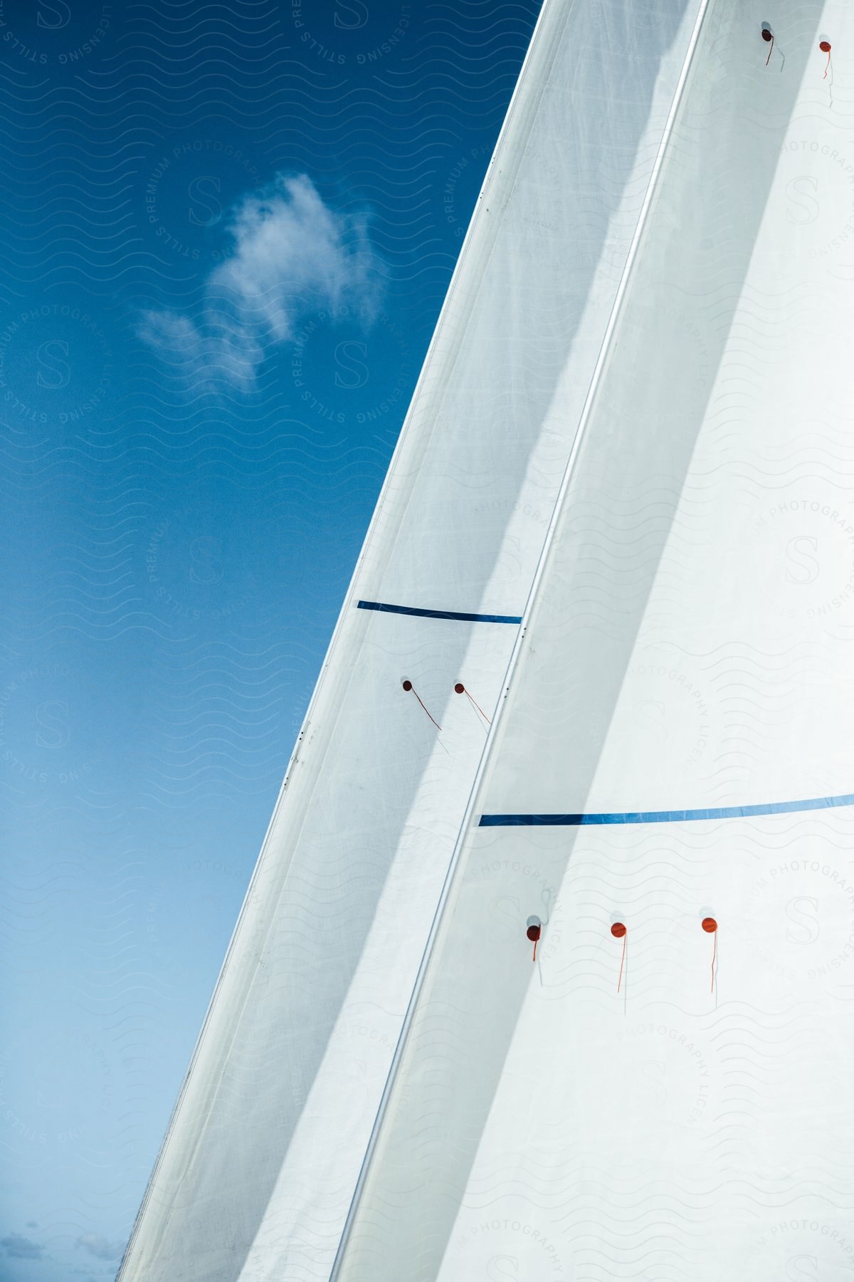 White boat sails against the blue sky