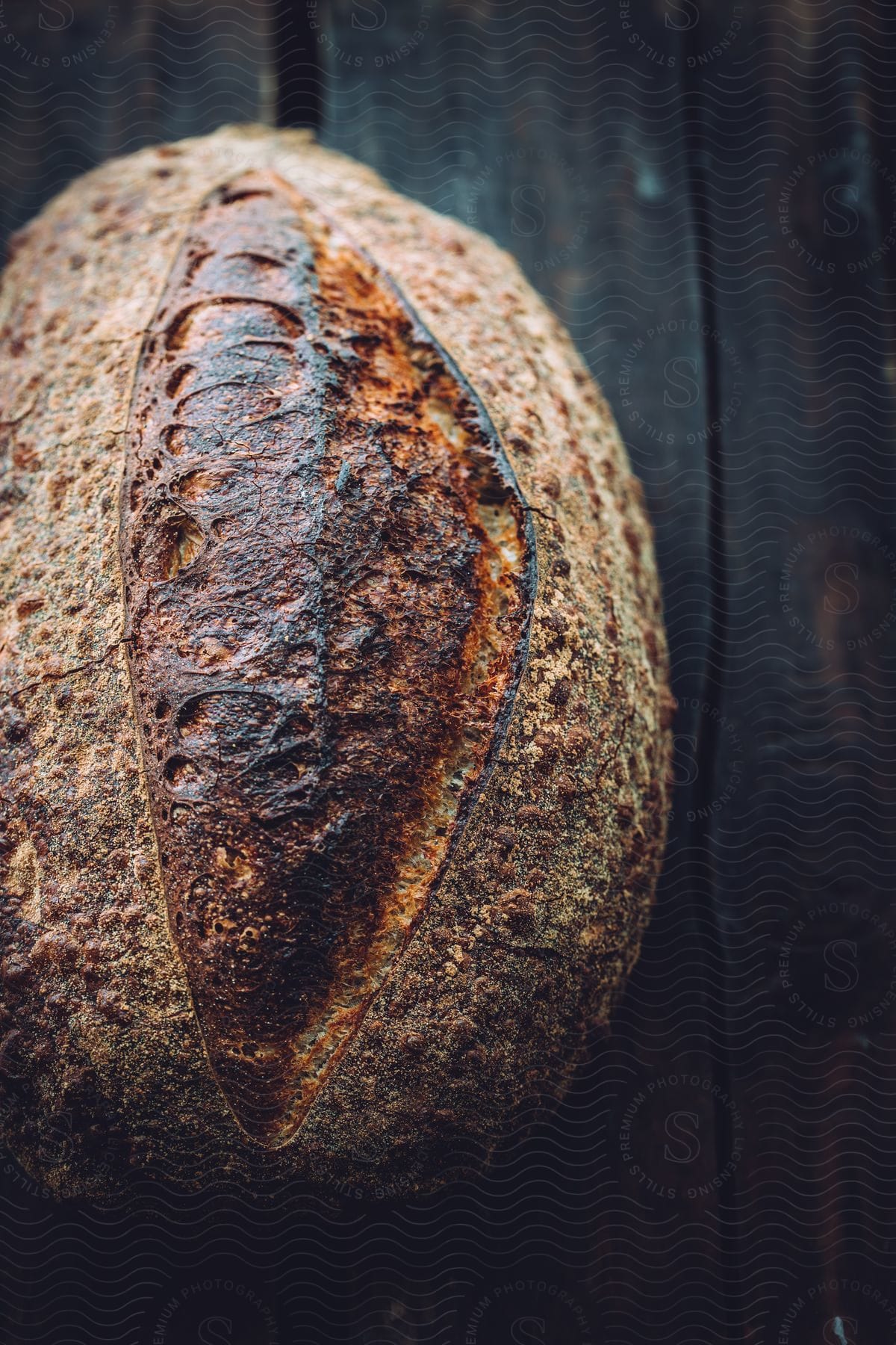 A loaf of sourdough bread on a wooden surface