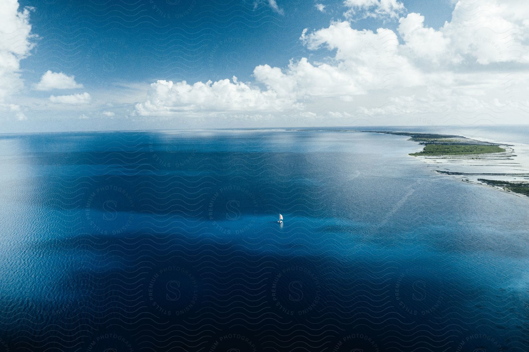 A boat drives on ocean water from an aerial perspective