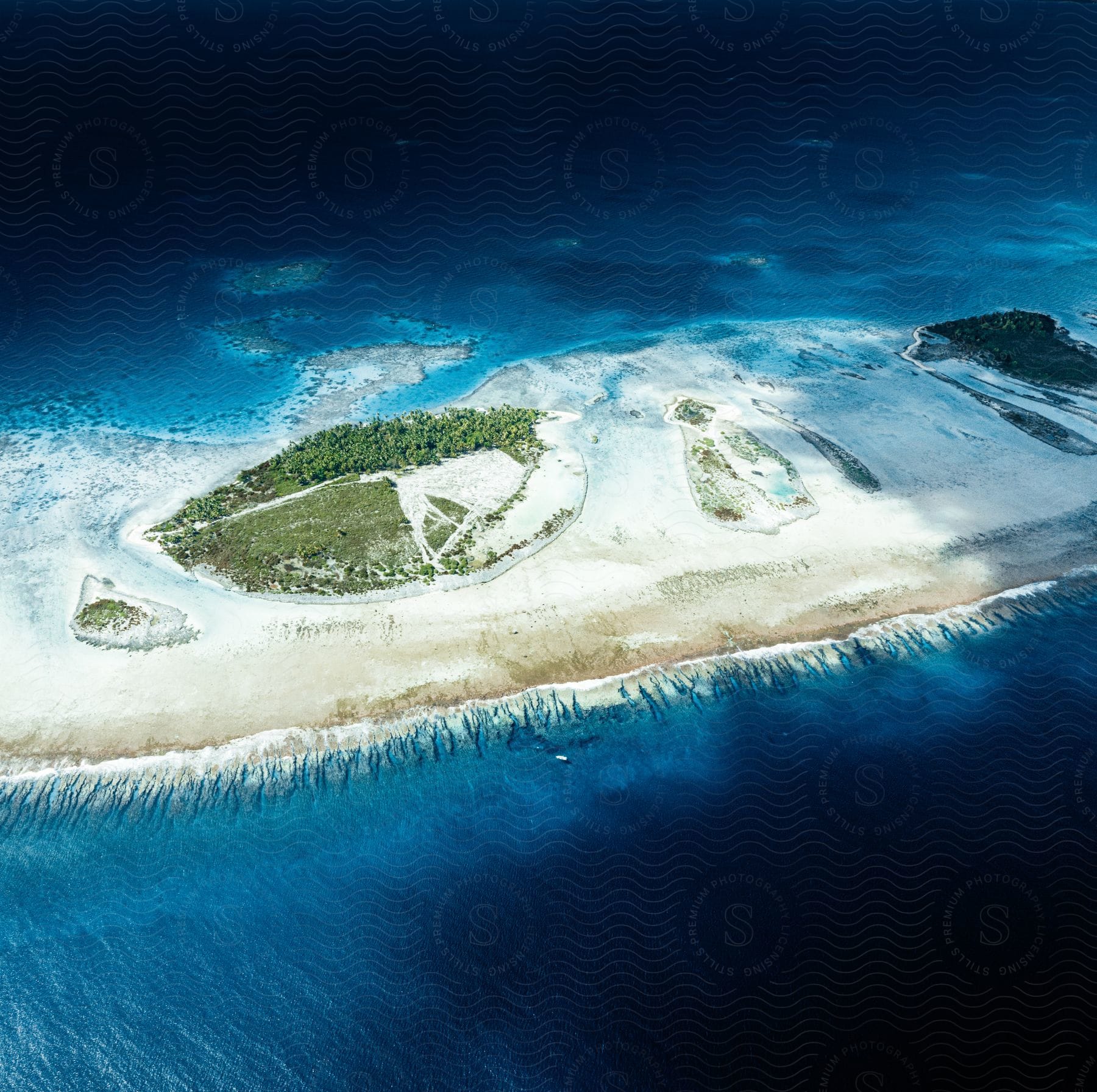 An island with trees and grass surrounded by deep blue sea