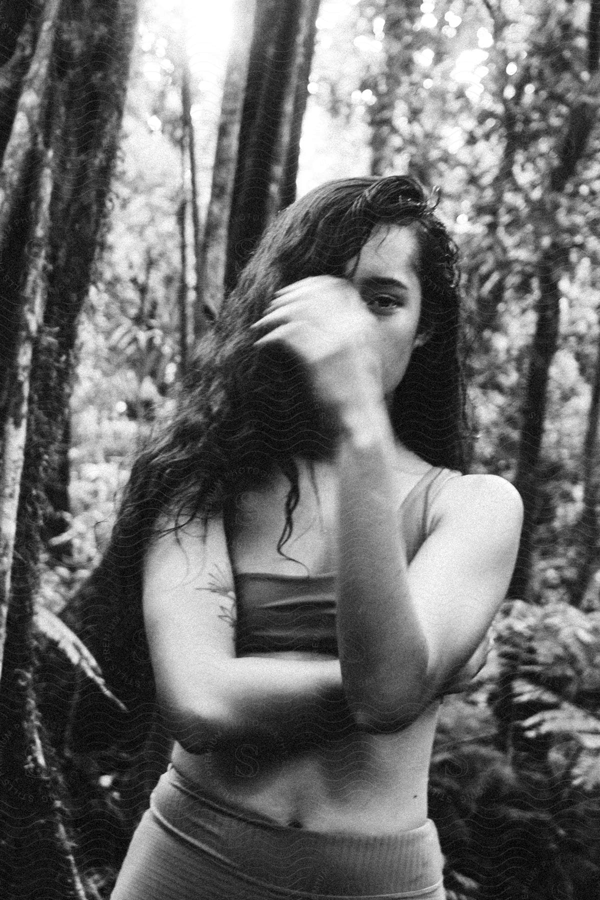 A woman standing in a jungle with black hair and a smile