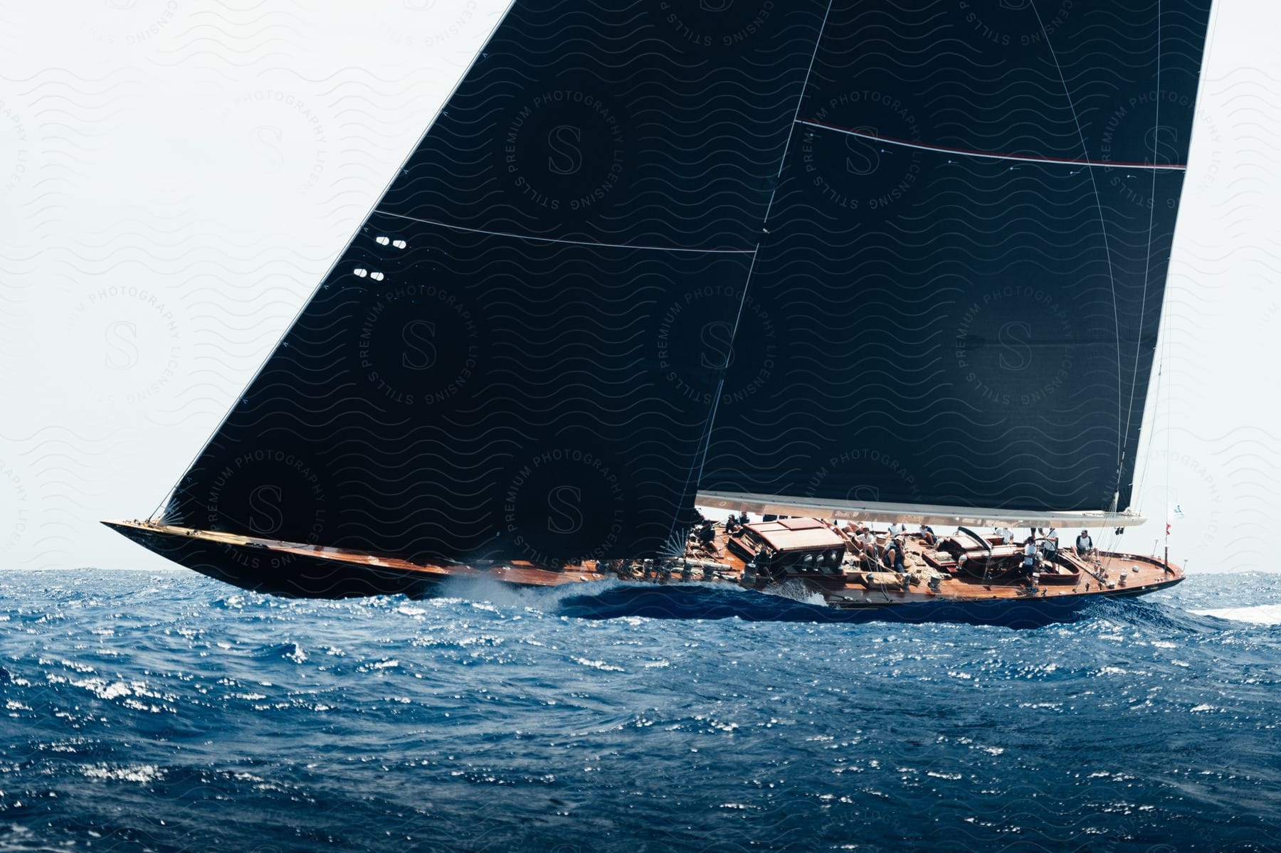 Sailboat glides on rough water with billowing sails navigating unpredictable waves and tilting the boat