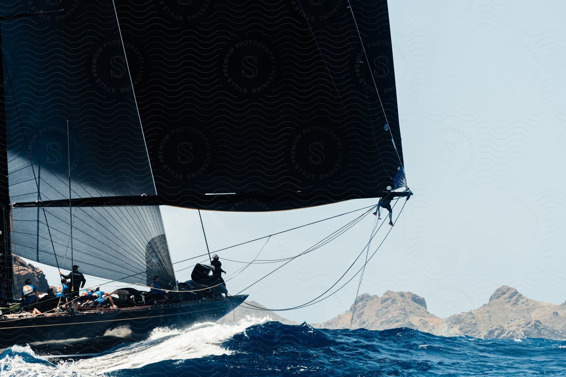 A group of people aboard a boat on calm waters with a covering on the boats top one person adjusting something in the front and a majestic mountain in the distance all under bright daylight