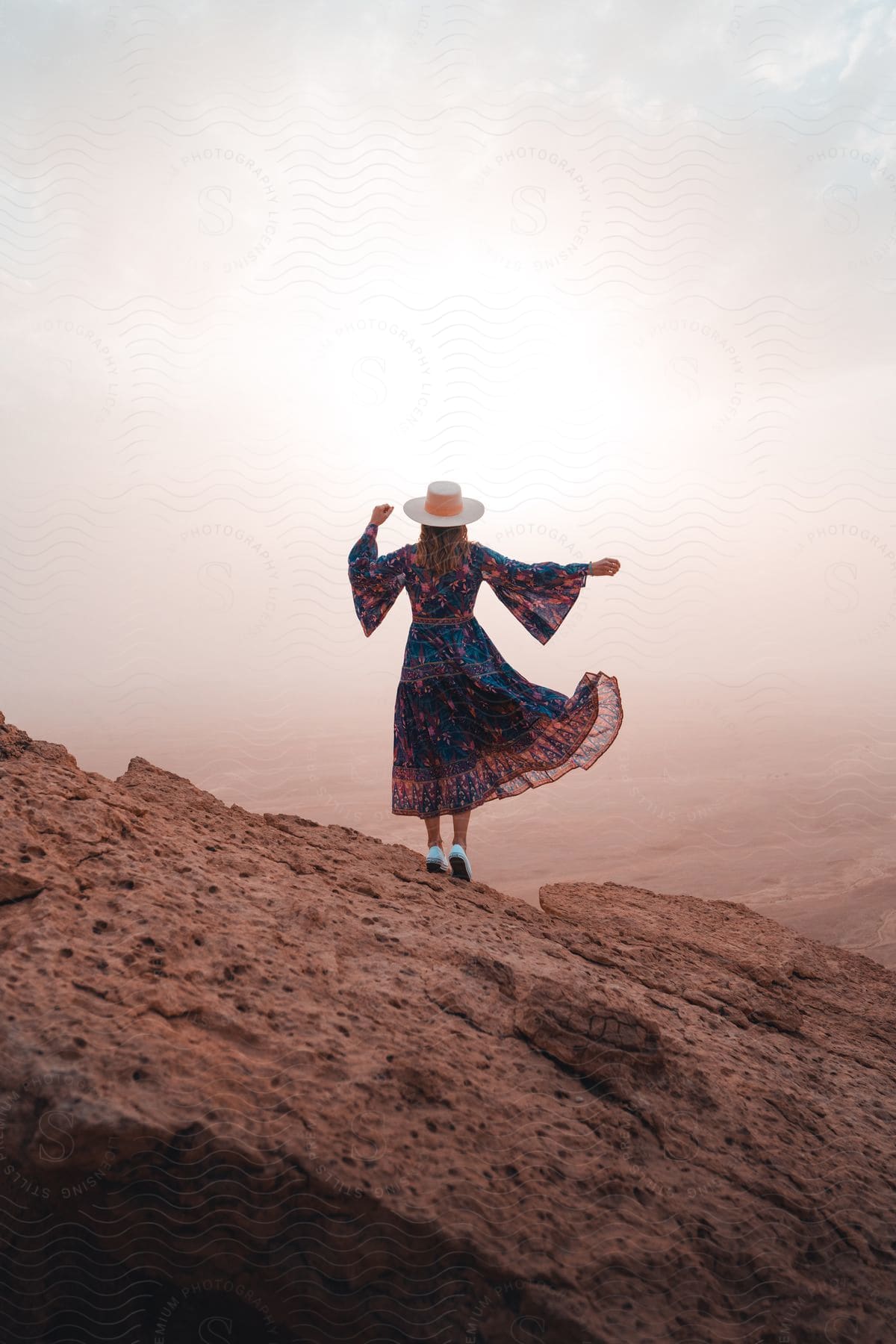 A woman standing on a rock in an outdoor setting