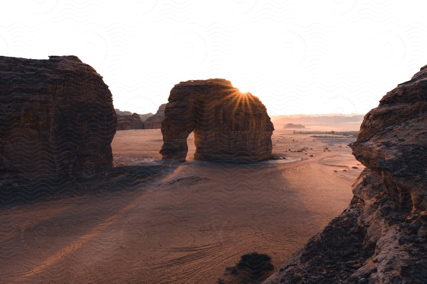 A rock formation surrounded by others in the desert at dusk with the last vestiges of light visible