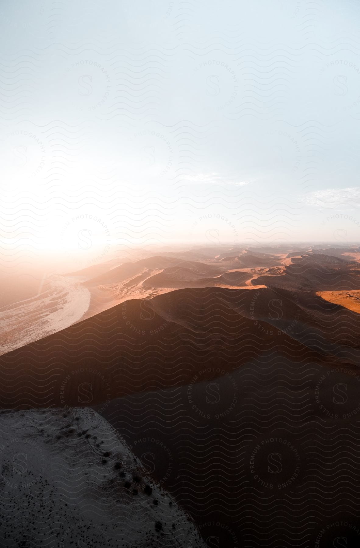 A desert dune at dusk with a cloudy sky