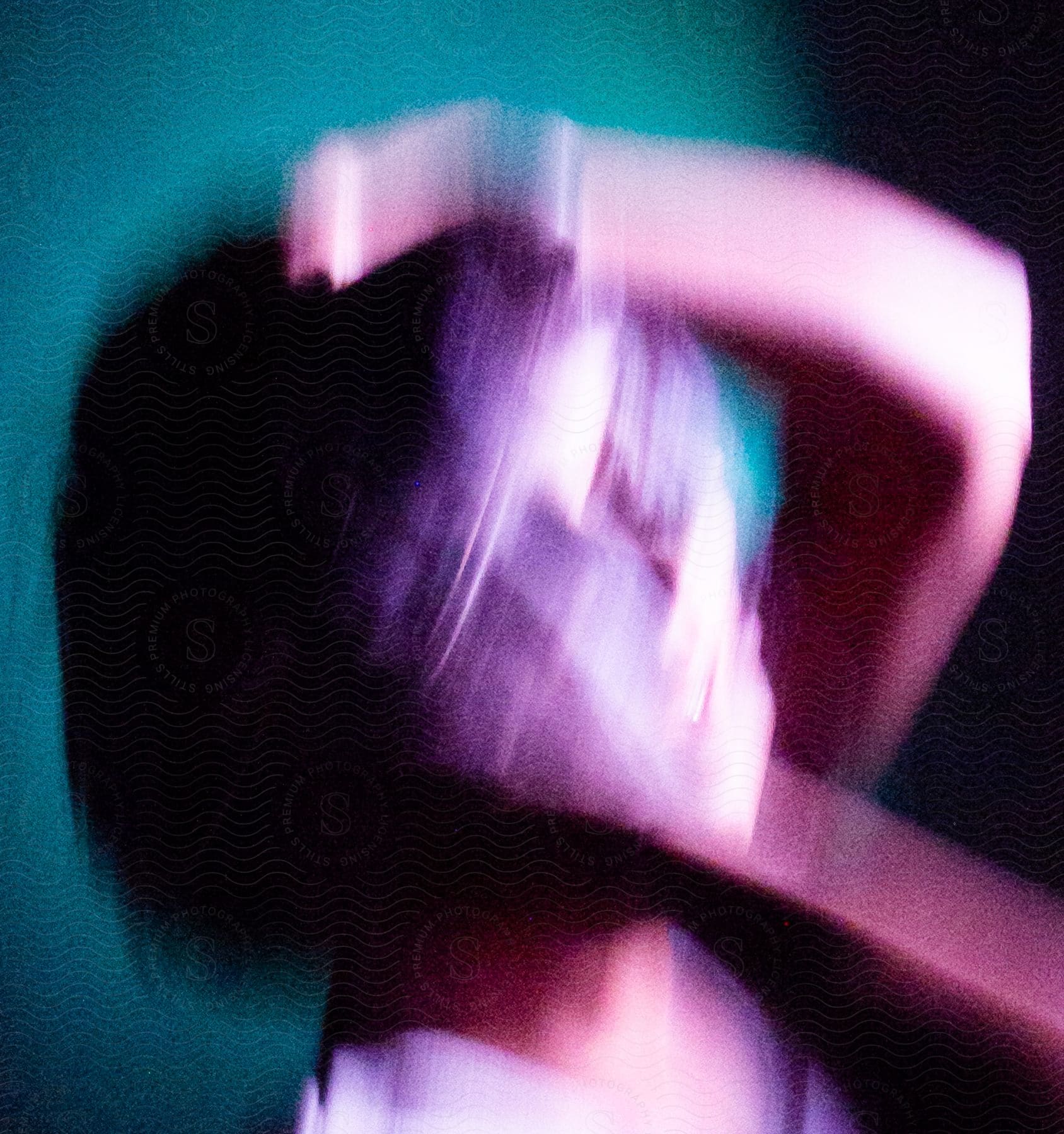 A person posing indoors with their hands and gesture distorted by motion blur