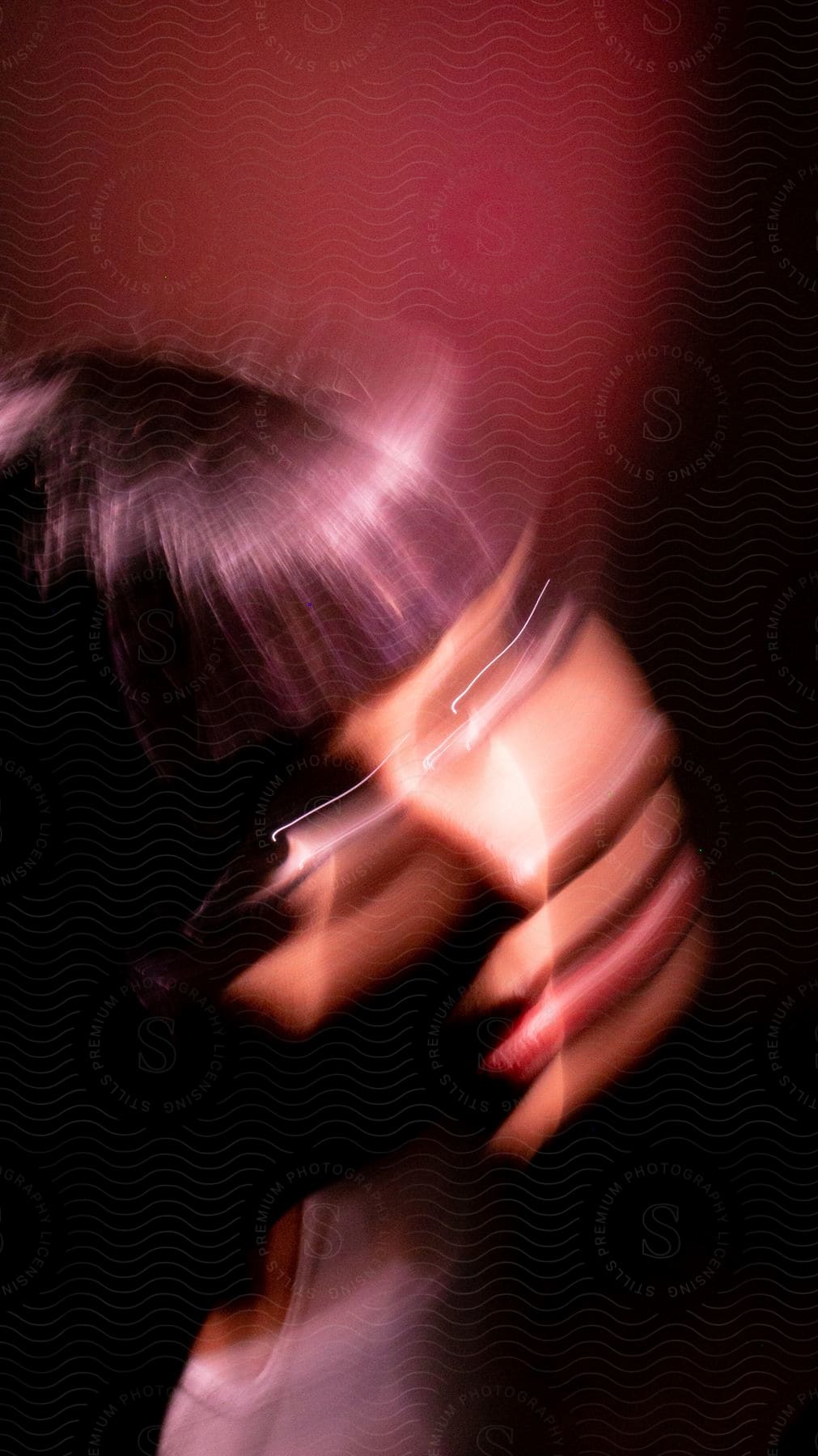 Close up of a young womans blurred face in motion in a studio setting