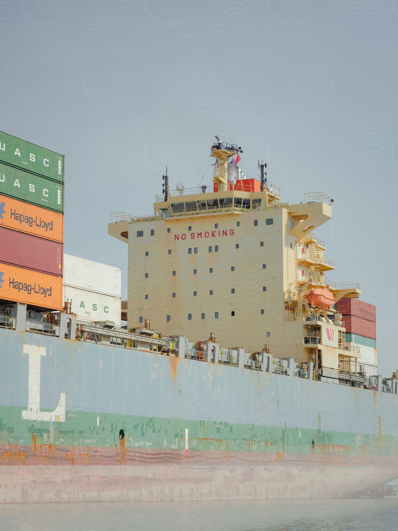 A container ship loaded with shipping containers under a blue sky