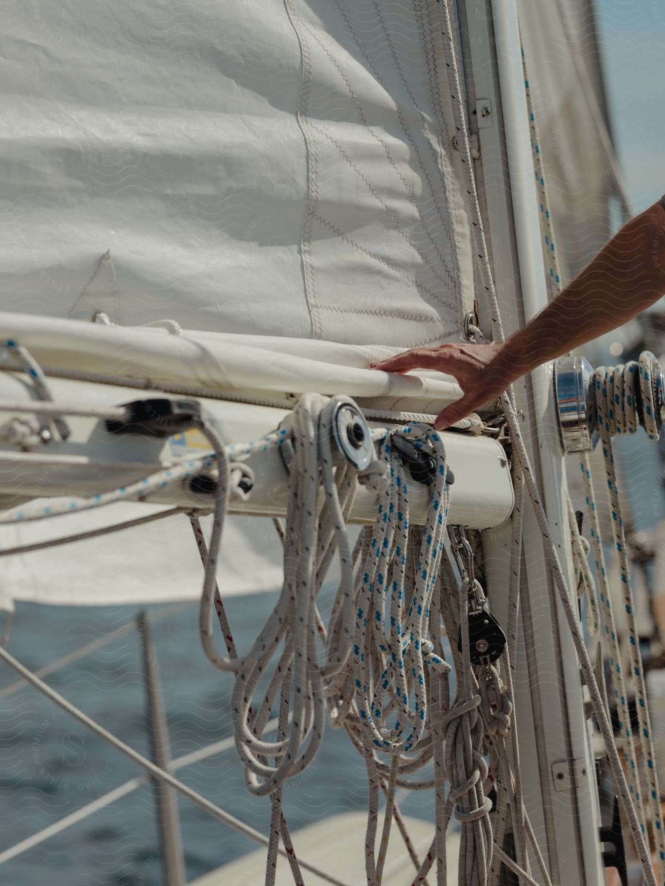 A hand approaching the ropes of a sailing boat