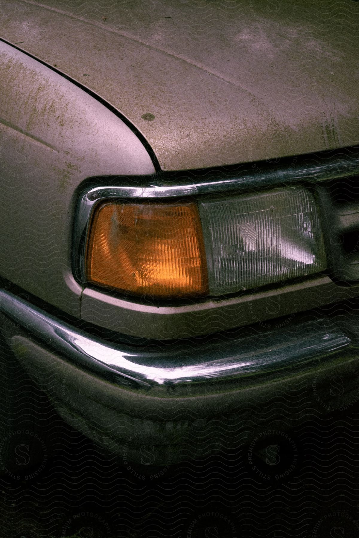 An old vehicle part possibly a car bumper or grille photographed at dusk or dawn in an exterior location