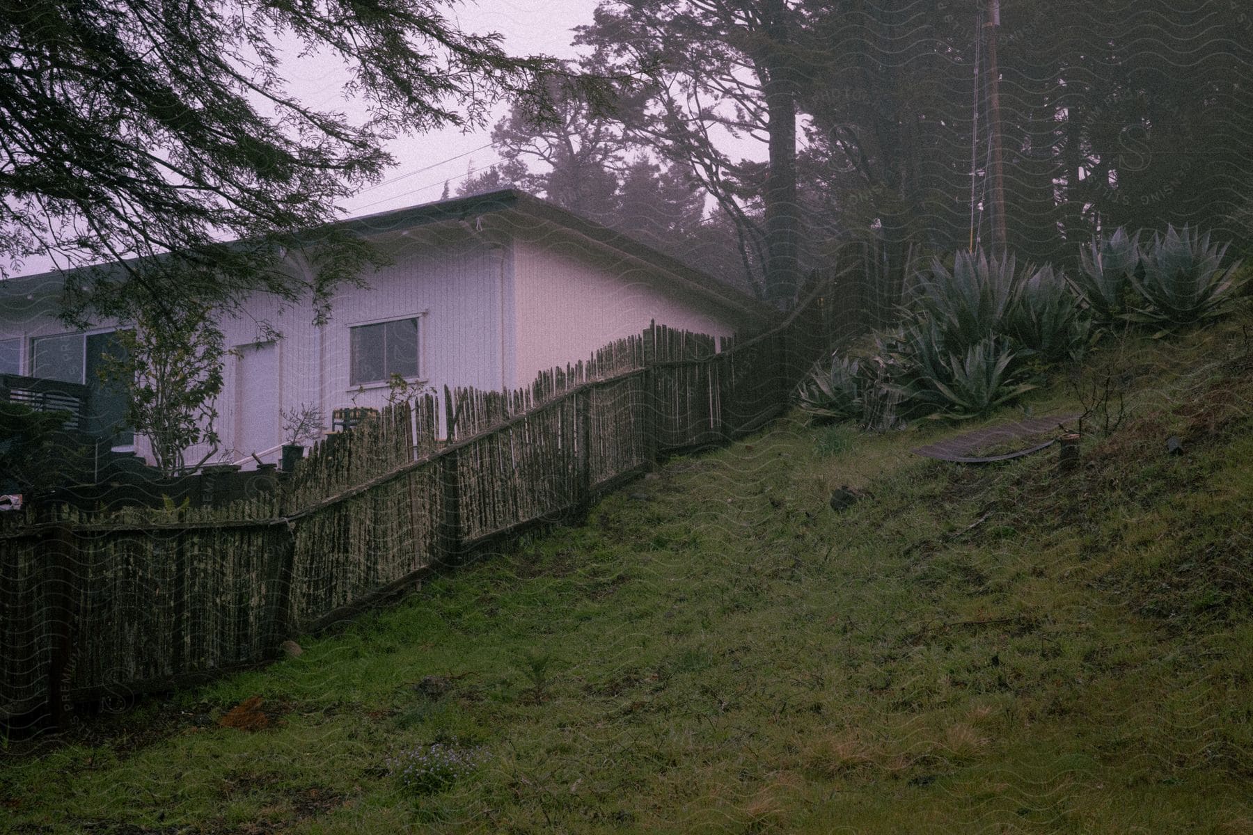 A Wooden Privacy Fence Surrounds A House In A Backyard