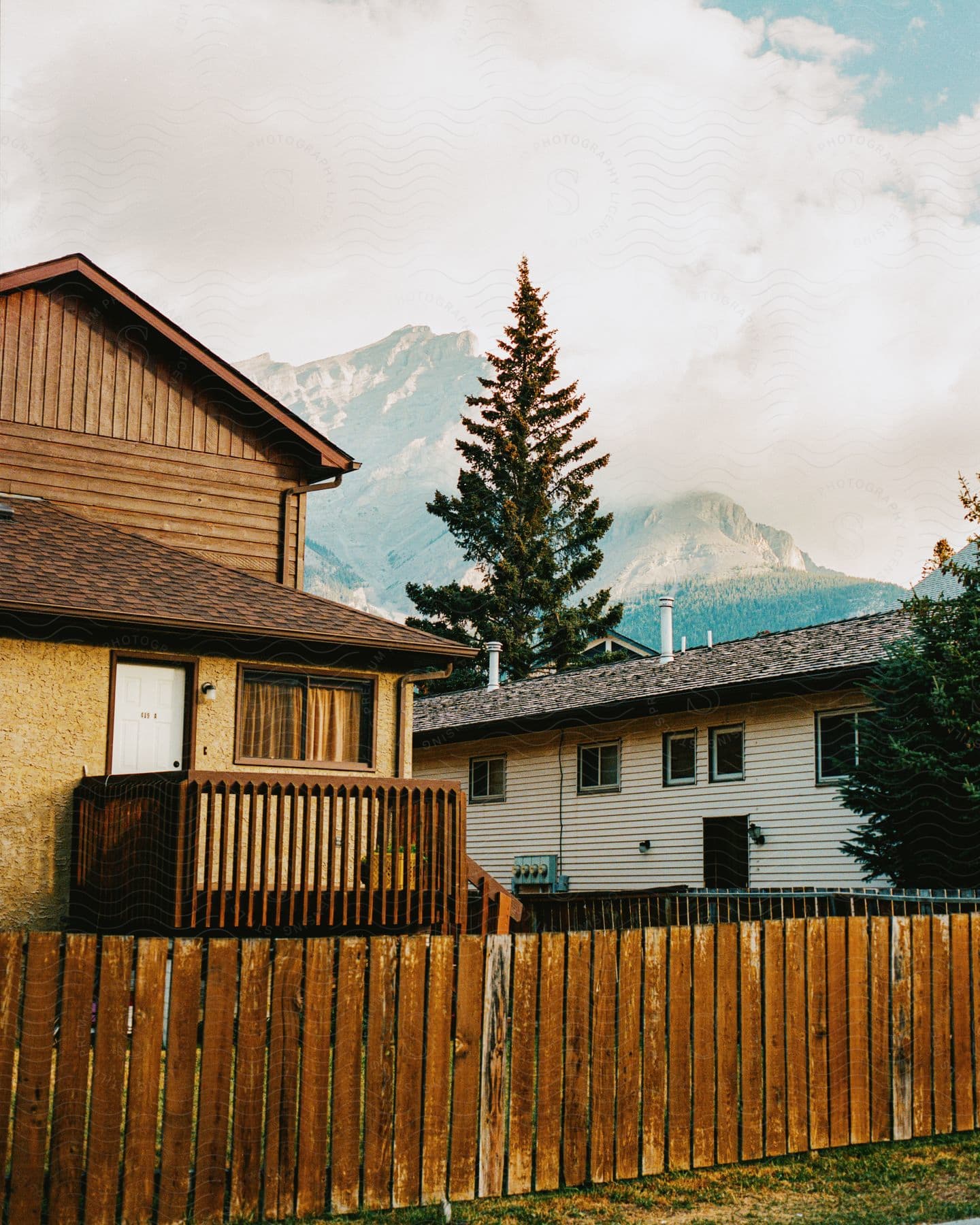 Houses outdoors near a mountain range with a picket fence in a residential area