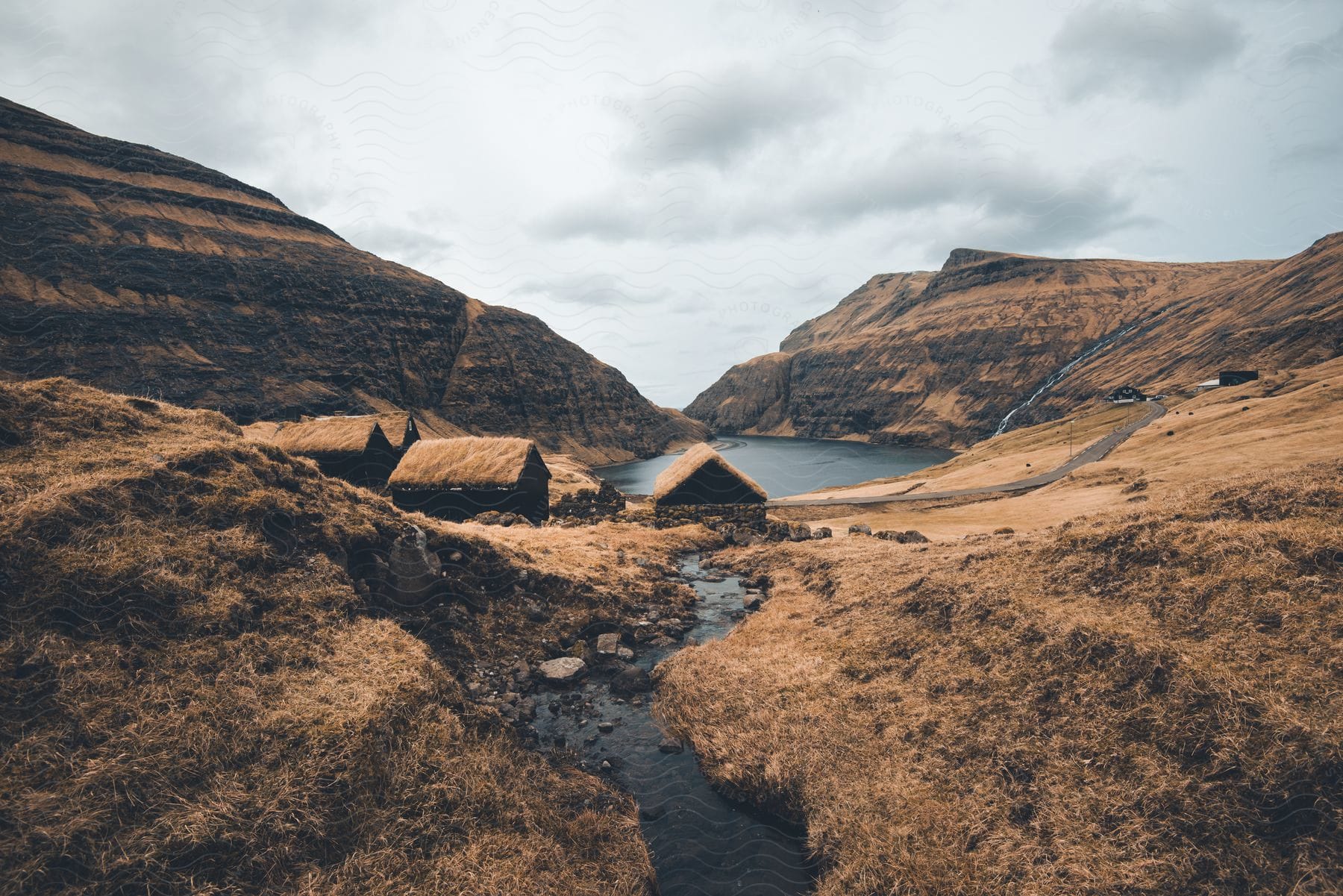 Buildings with thatched roofs near a mountain stream