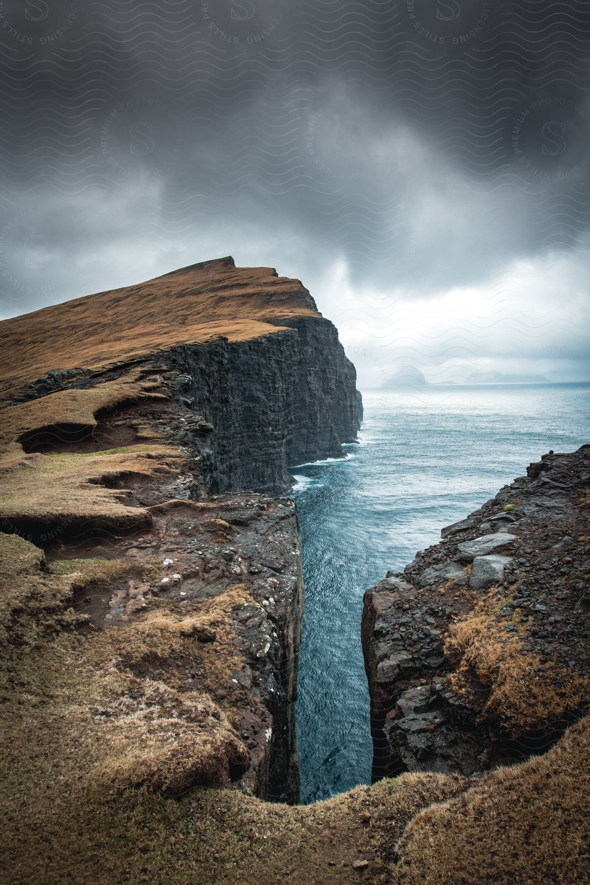 Leitisvatn sørvágsvatn the largest lake in the faroe islands captured from an aerial perspective during the day with high key lighting showcasing the scenic coastline rocky cliffs and cloudy sky