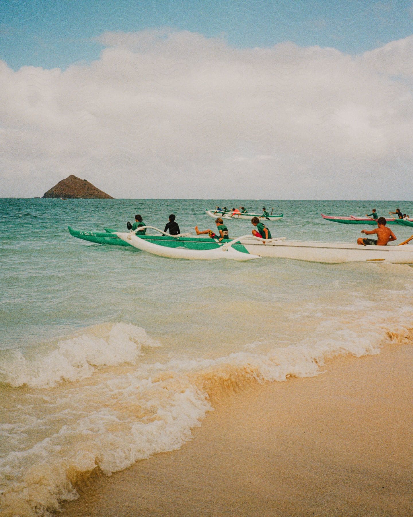 A small crowd of people in boats near the beach