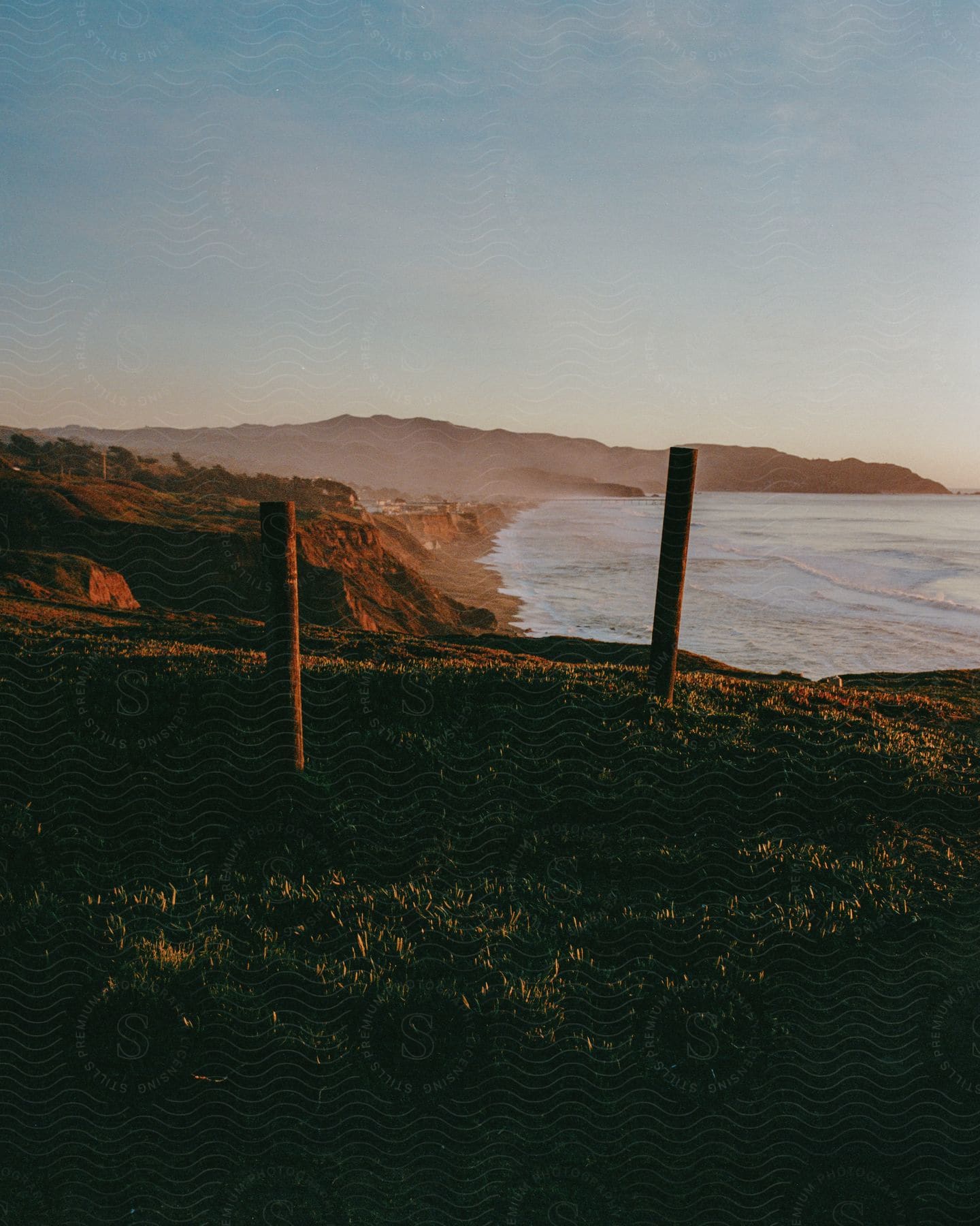 Wooden posts planted on hillside by the ocean