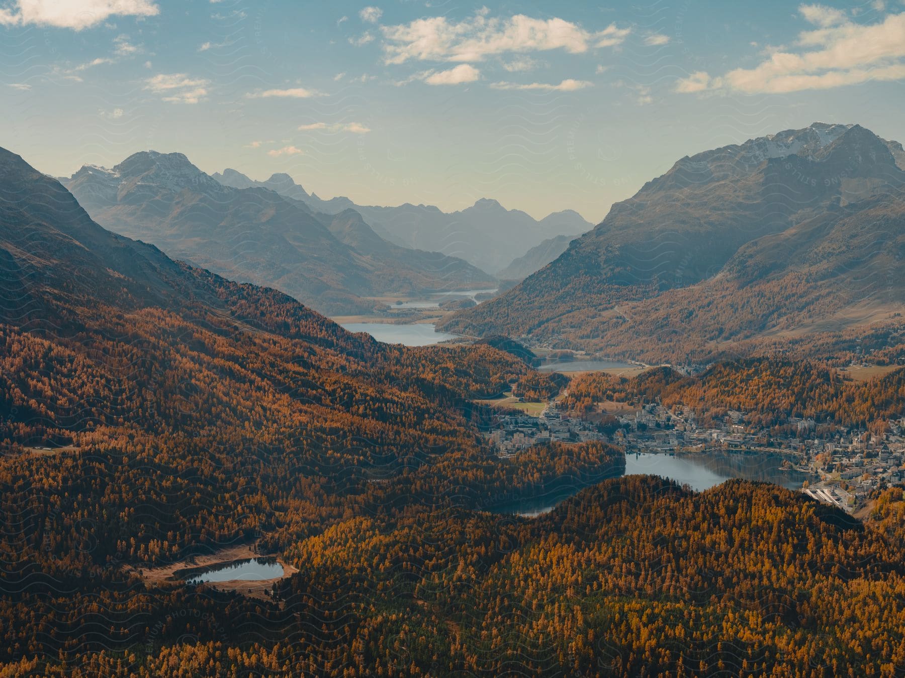 A lake surrounded by forested mountains in the distance