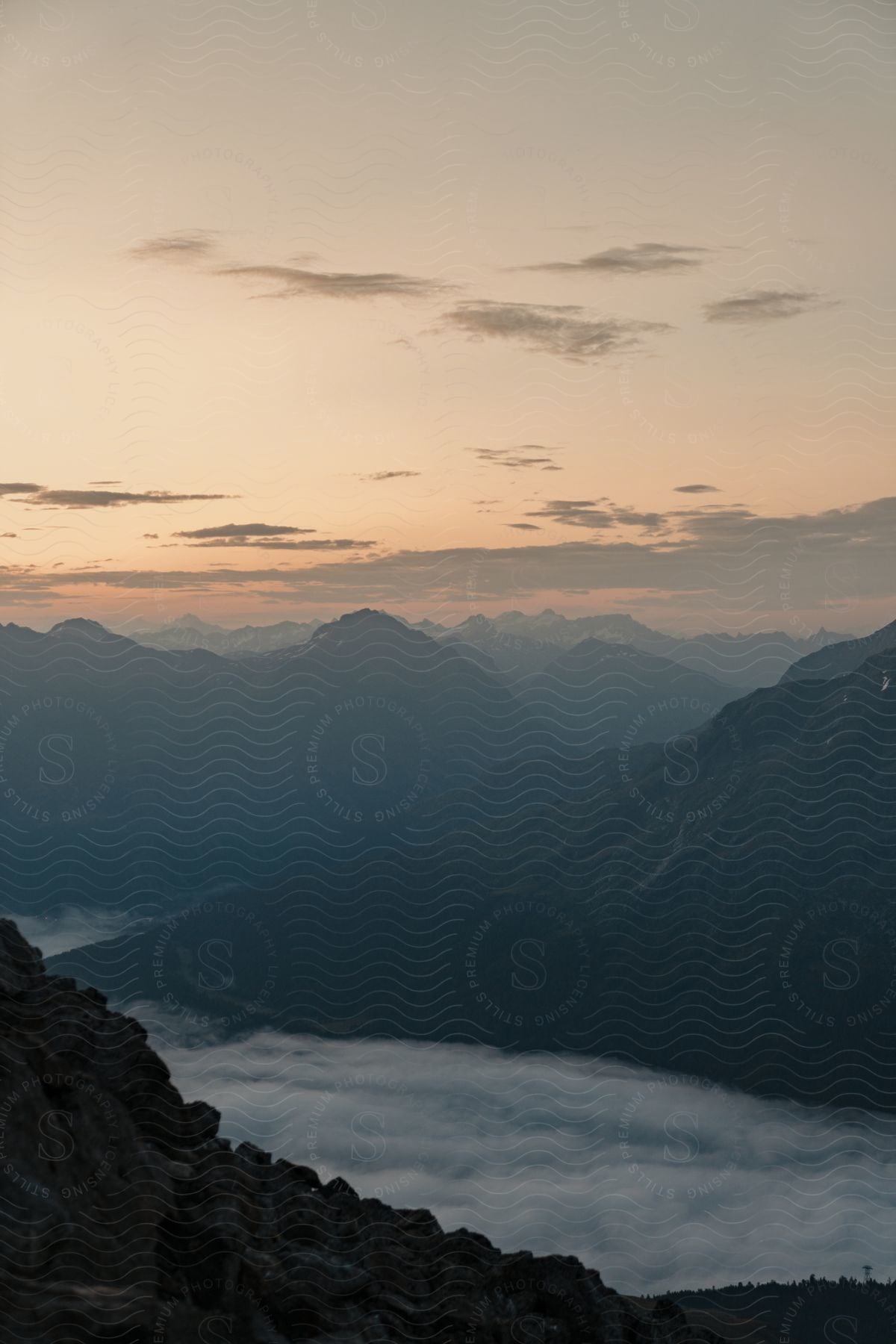 A mistcovered lake with mountains visible in the distance on the horizon