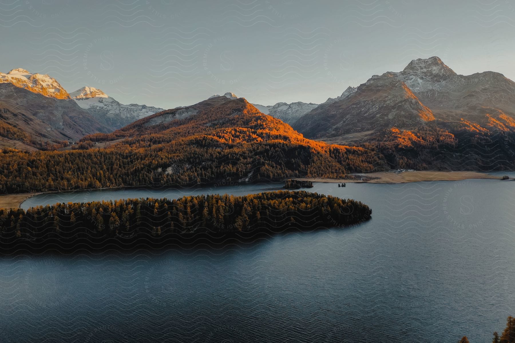 Lake at the foot of a mountain range with sunlight and changing season