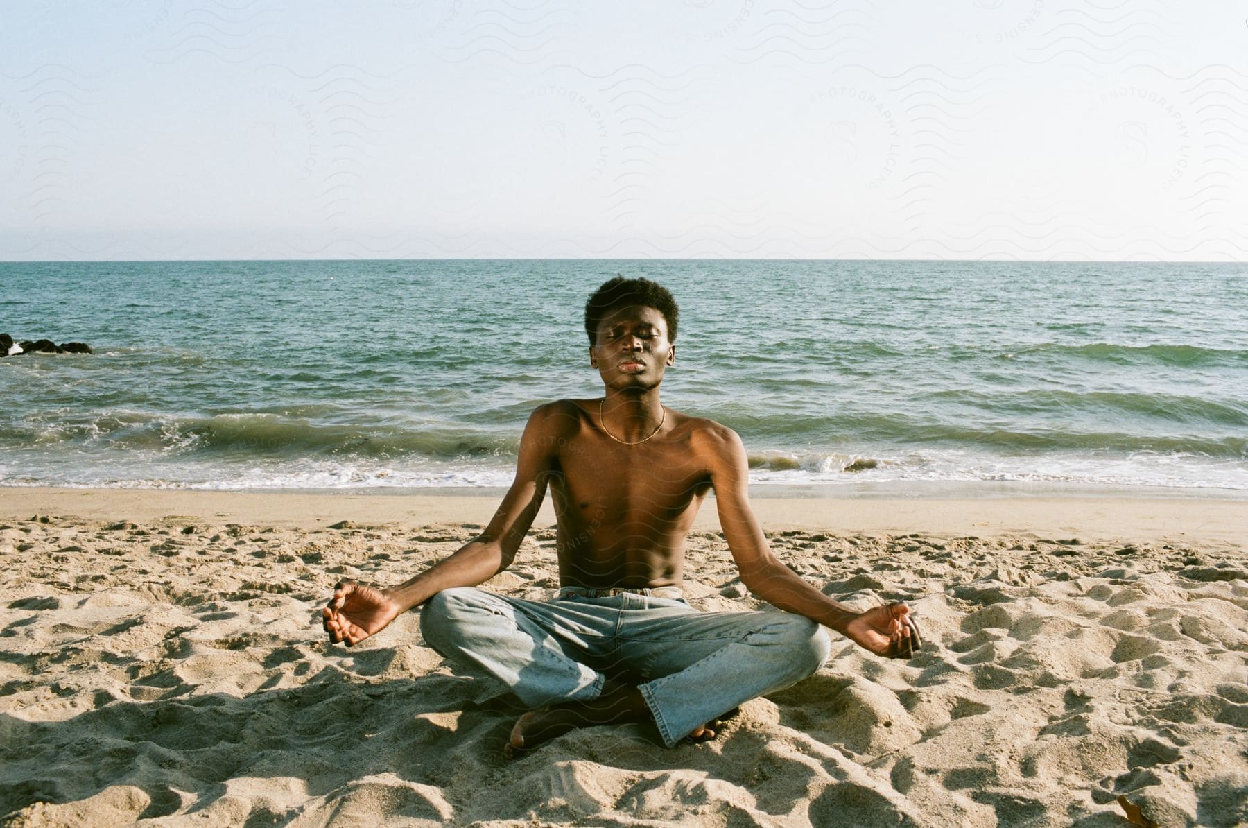 An africanamerican teenager meditating on the beach