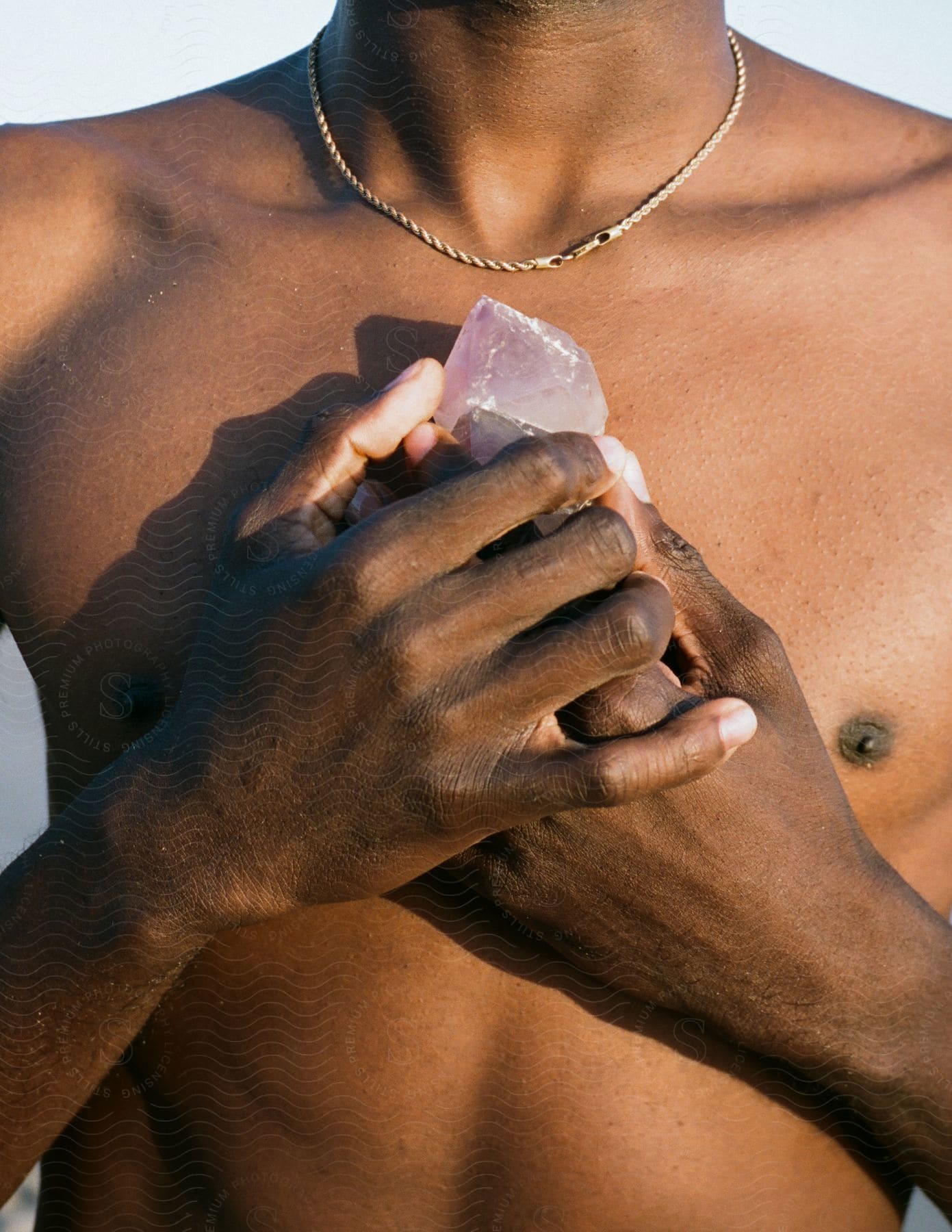 A person with black hair meditating on the beach