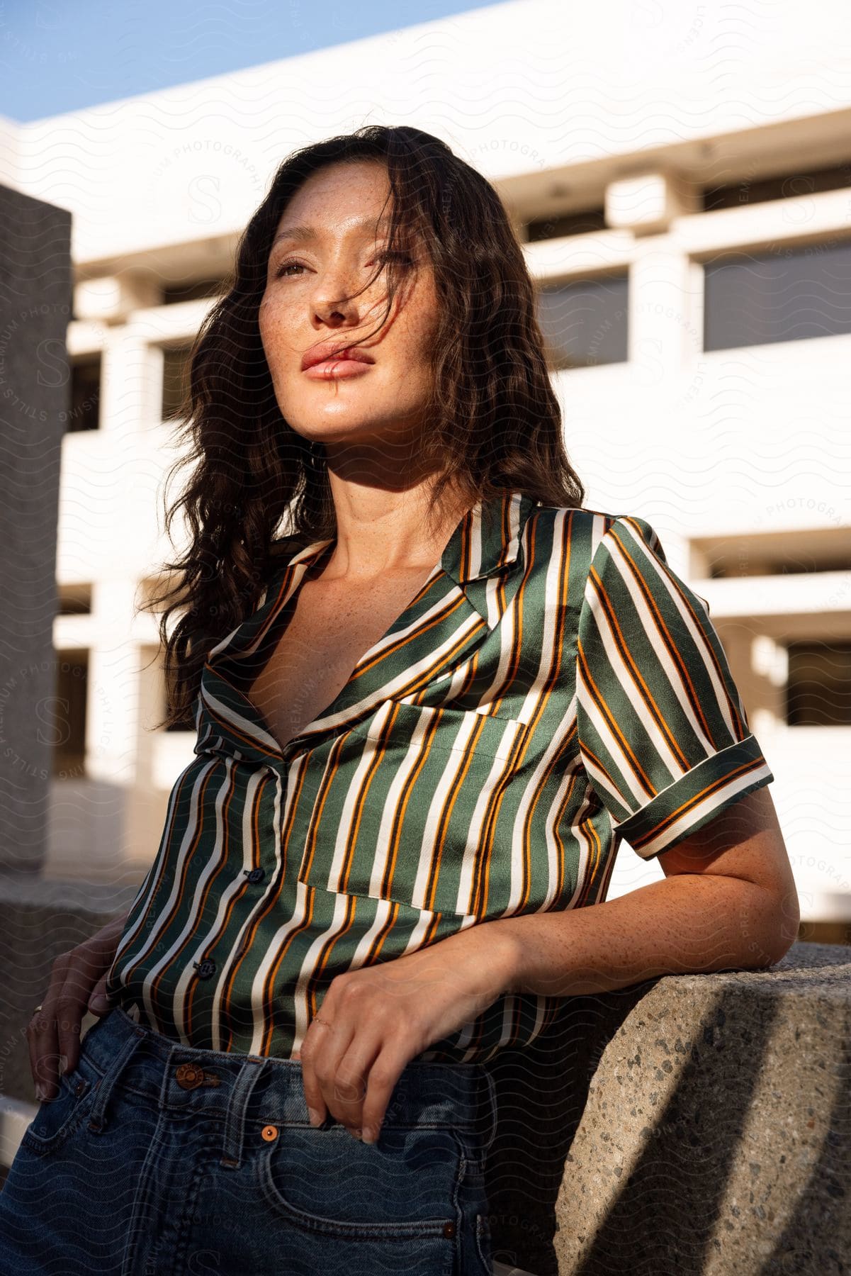 A woman with black hair and a smile wearing a blouse and pants excited and carefree in los angeles