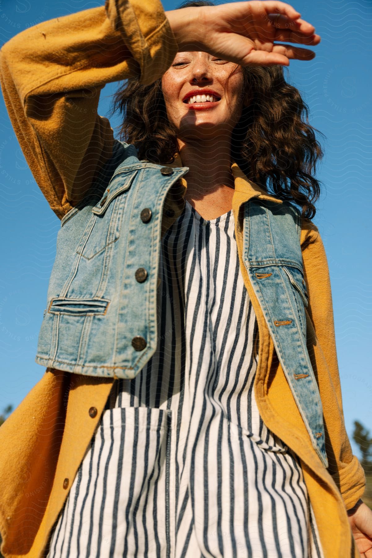 Stock photo of a person with a happy expression wearing a coat and jacket looking up at the sky