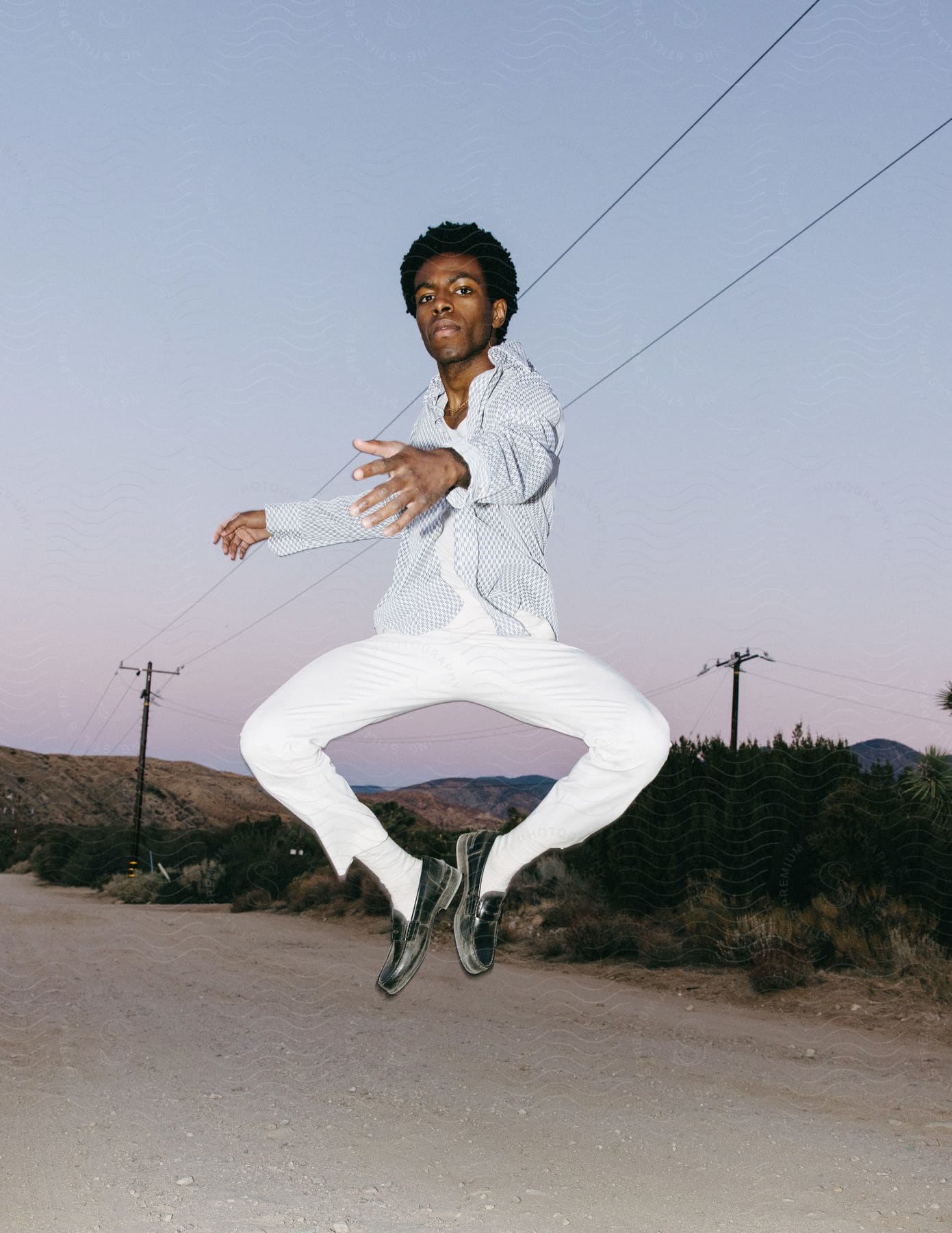 A man performs a trick as he jumps or floats in the air in the california desert during the day