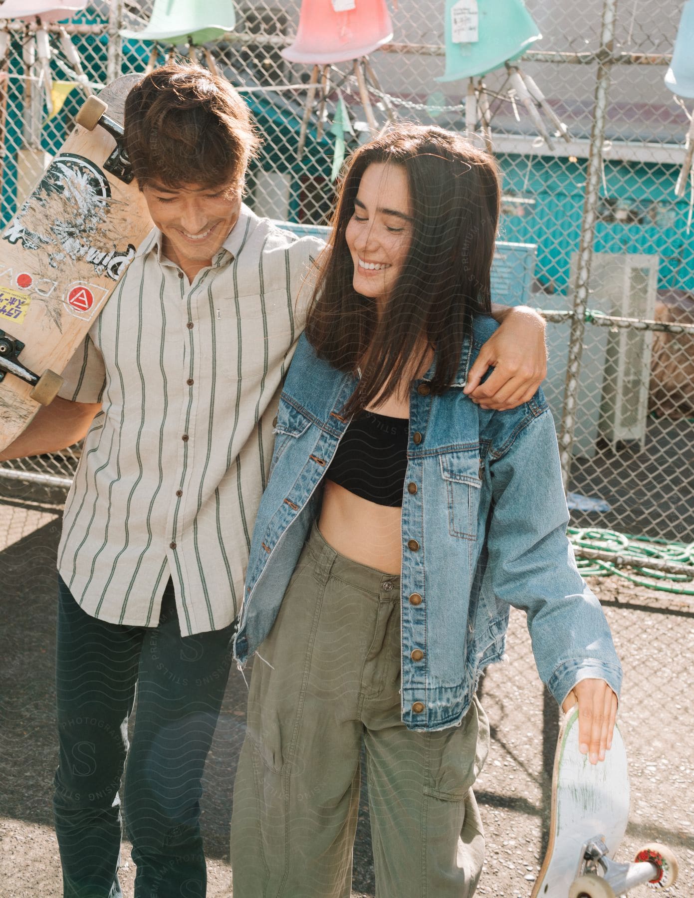 Two people a girl and a teen with brown hair wearing a coat and pants are standing and laughing together