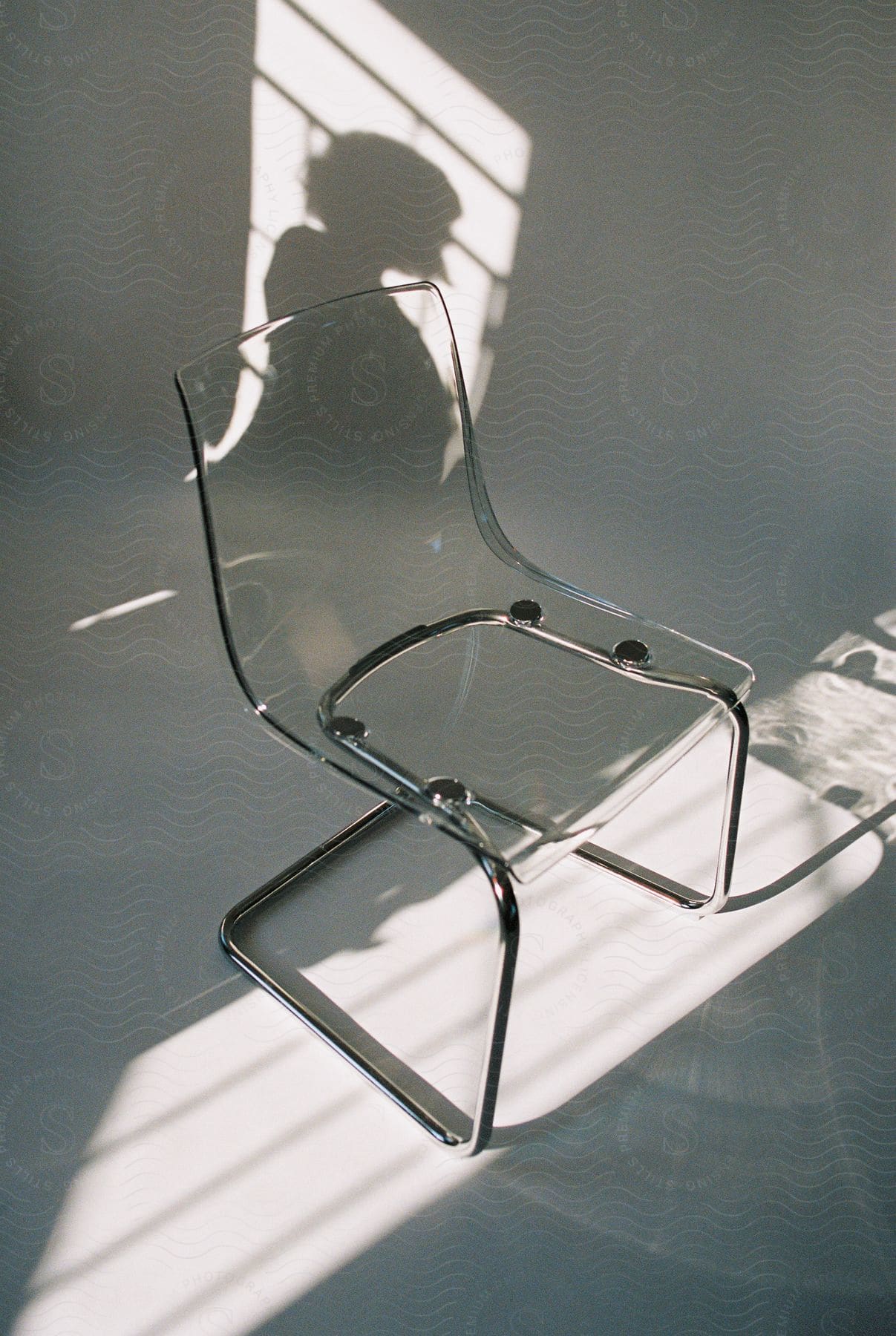 A Clear Chair In A White Room With A Shadow On The Wall