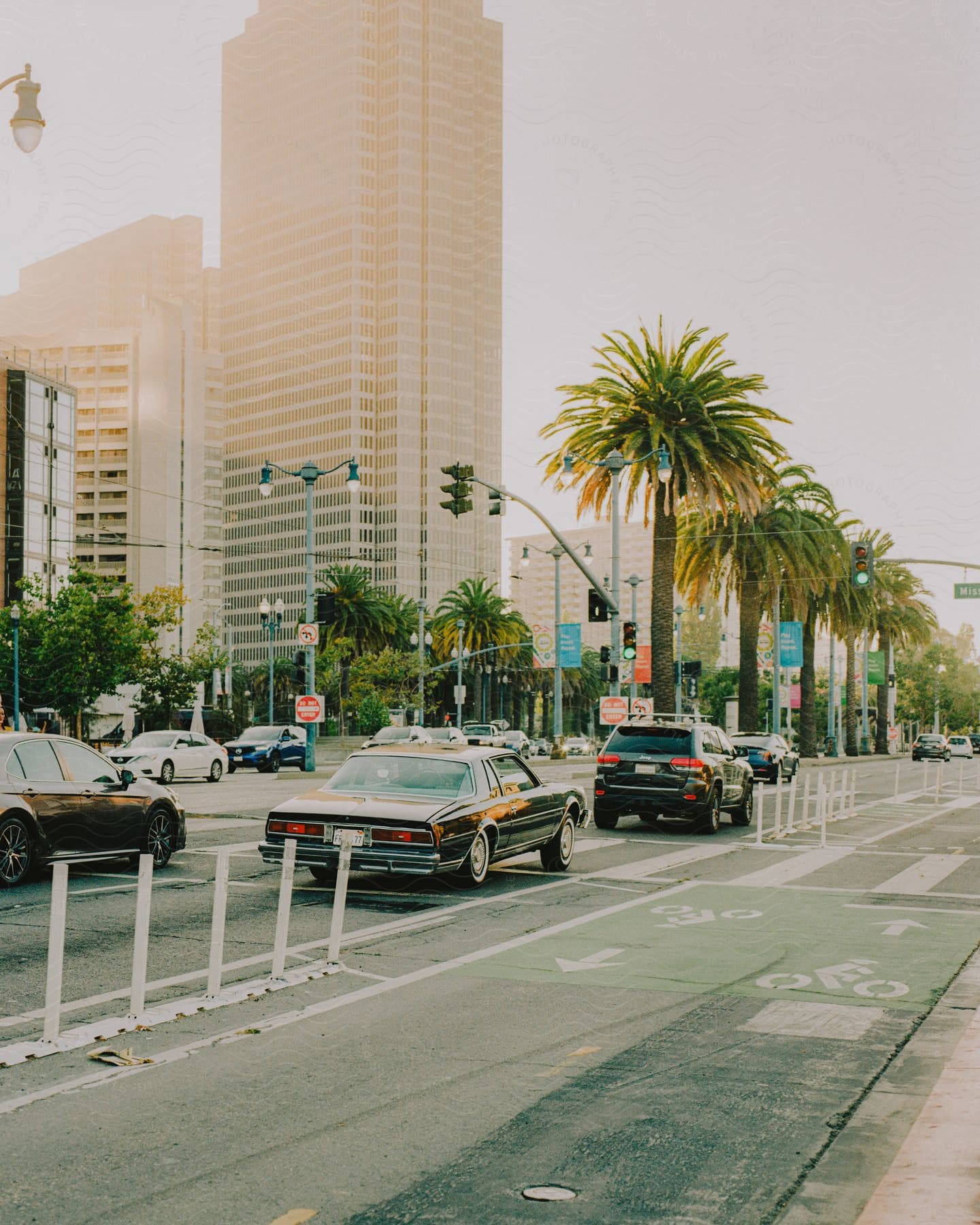 Cars driving through a city street during the day