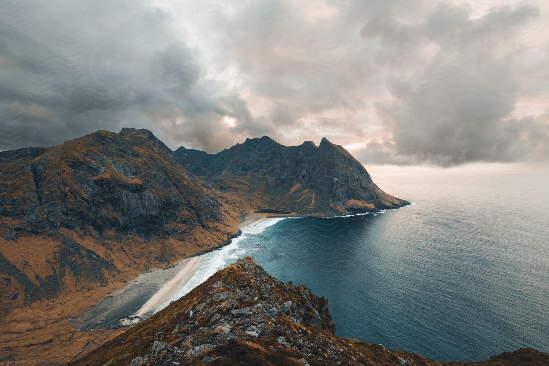 Waves crash on a small beach near a mountain range