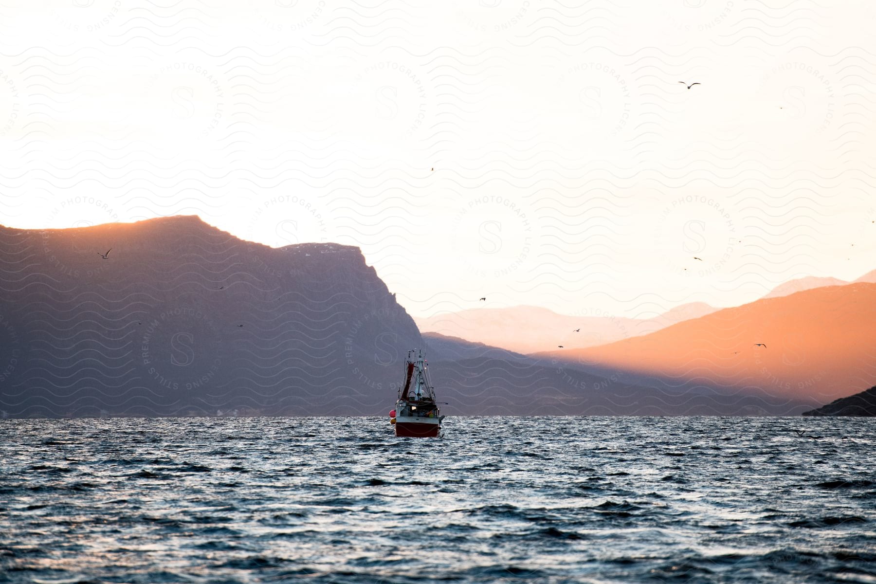 A boat sailing on the ocean at sunset