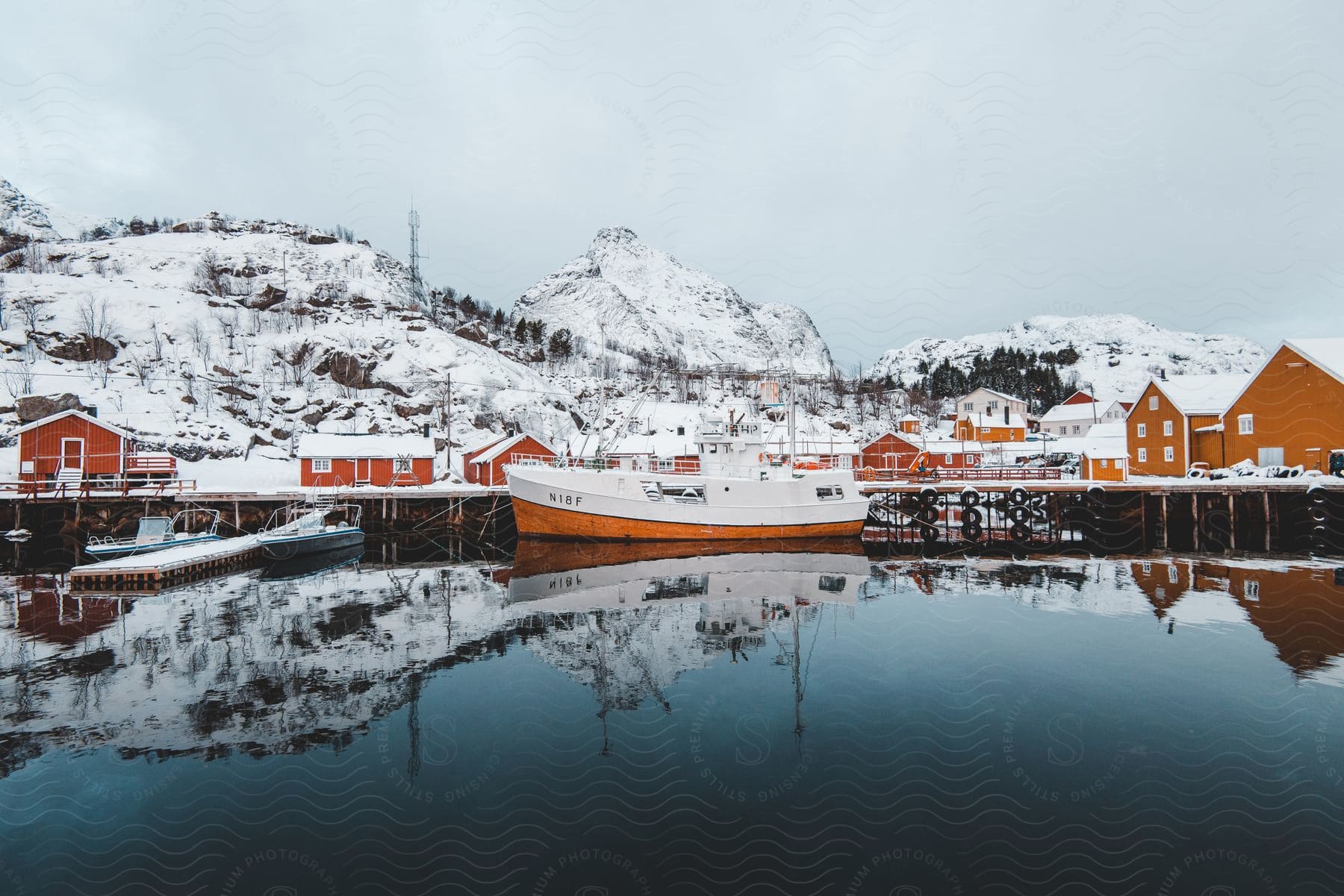 A fishing boat docked at a pier in an arctic coastal town