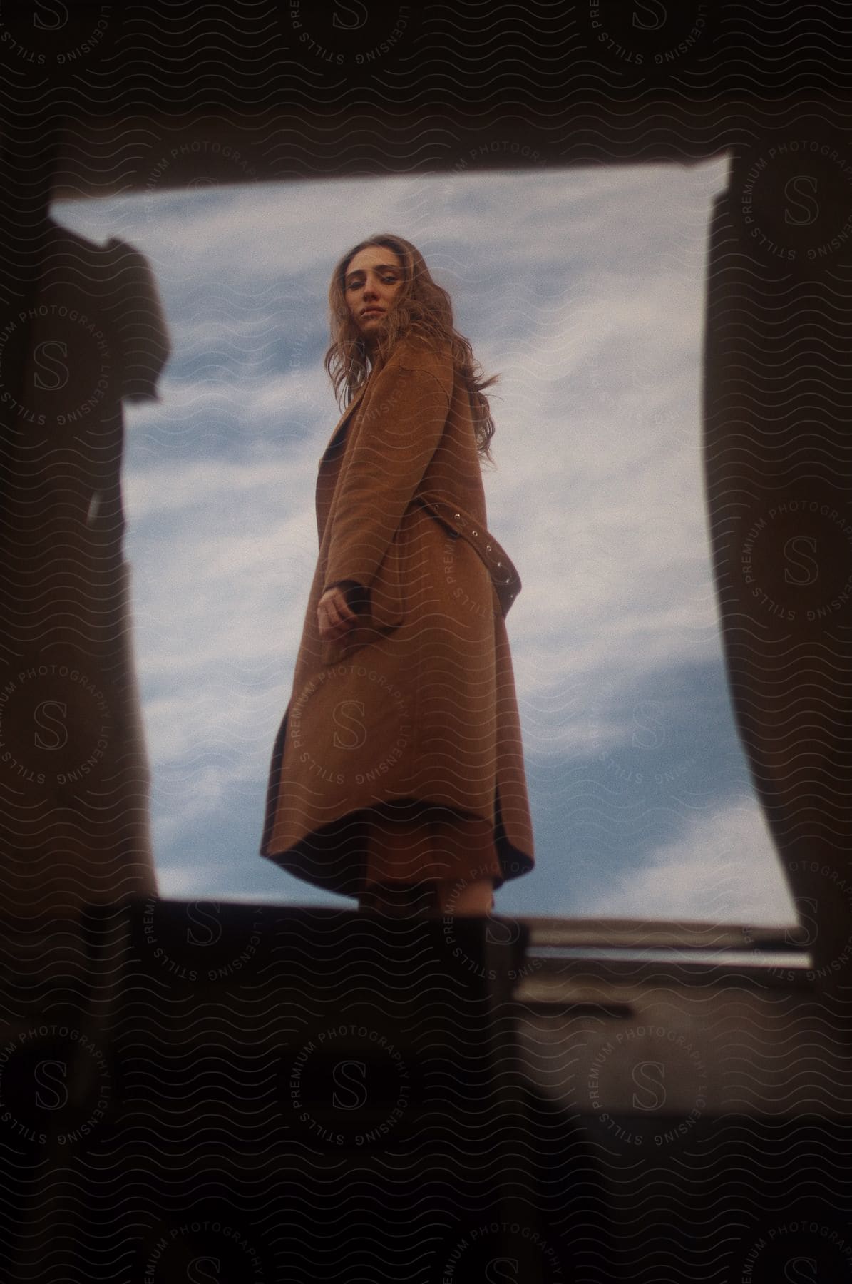 A person standing in front of an abandoned plane looking happy and carefree