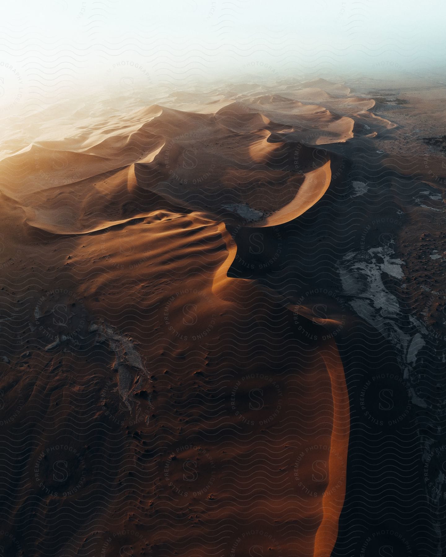 Sand dunes in the desert under the mist at sunset