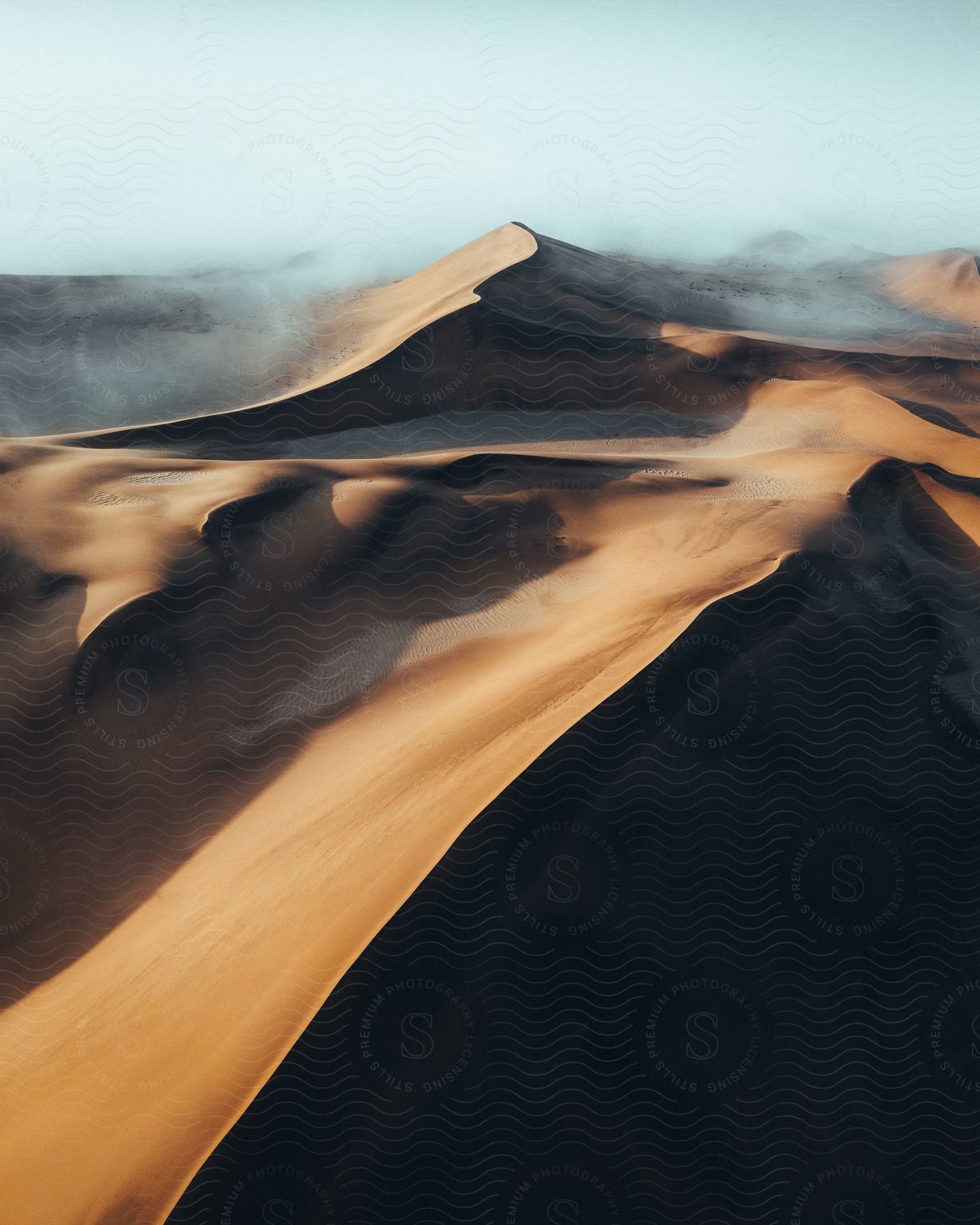 Wind blowing over desert sand dunes seen from above
