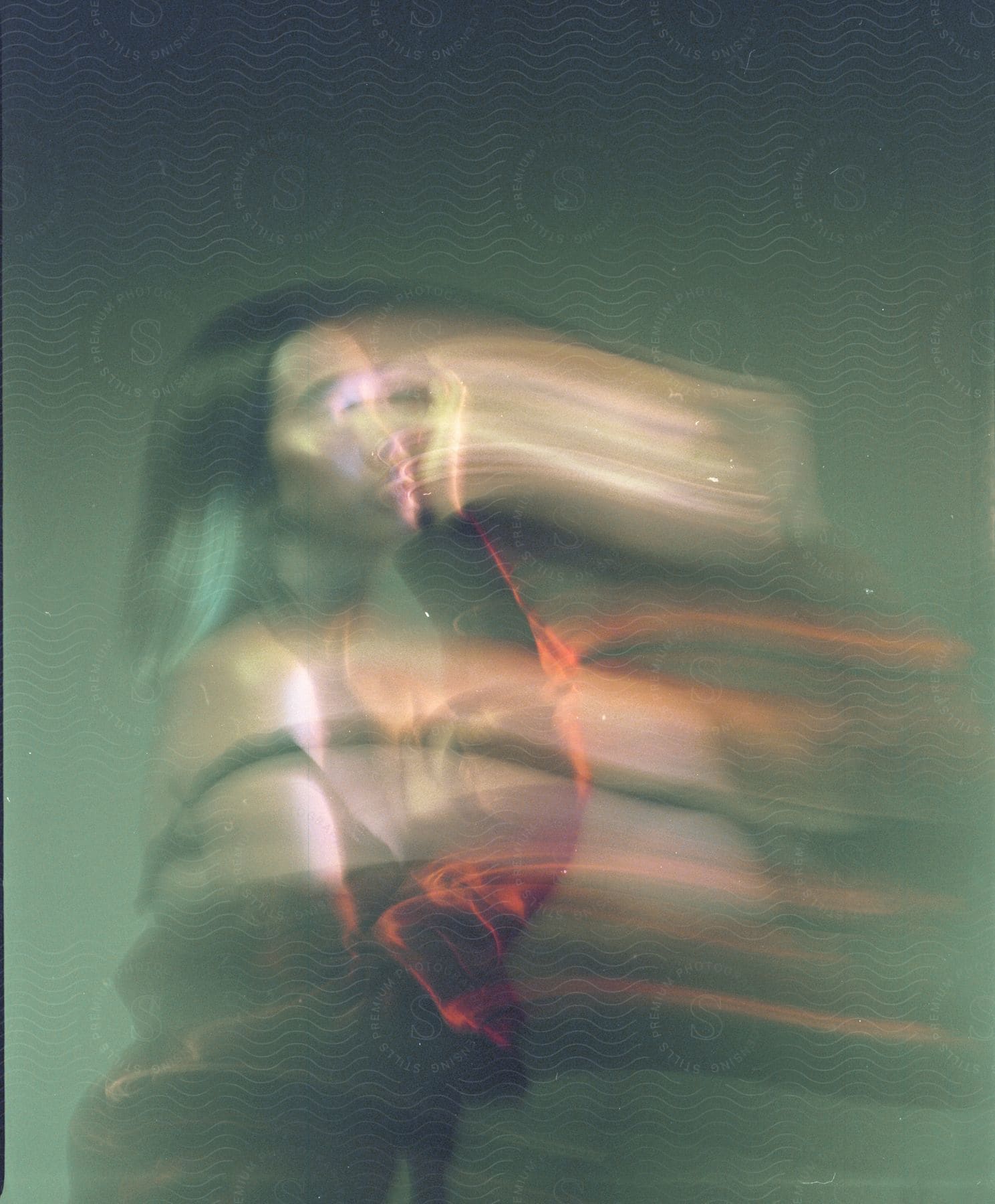 Blurred figure of a young woman partially obscured facing a direction leaving the viewer intrigued and curious